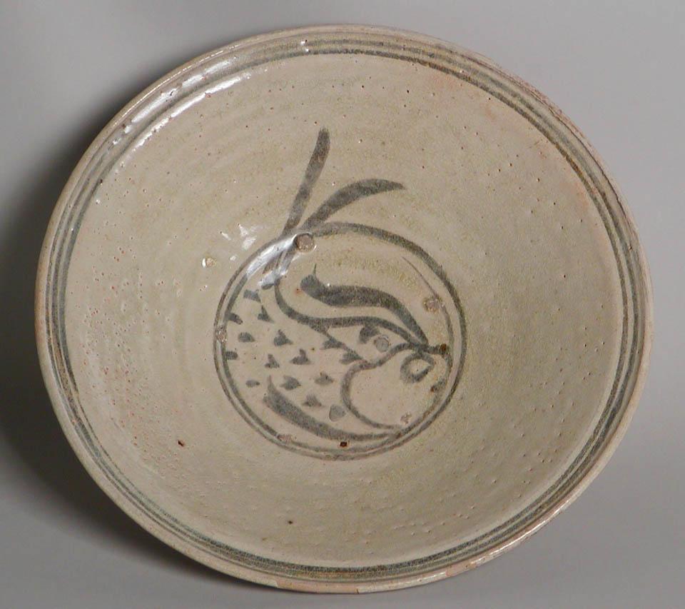 Antique Thai Fish Bowl, Sukhothai Kilns. A deep stoneware bowl with black slip painting of a fish with his tail extending beyond the concentric band on center, further band decoration at the lip and outside wall, covered overall in a crackled milky