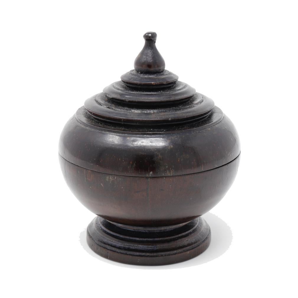 Antique Thai Hardwood Betelnut Box. 
A turned wood globular chedi form having a narrower pedestal base, fitted wood conical top shaped with circular tiers and a lotus bud finial. Crafted for the nuts or spices associated with the ritual of chewing