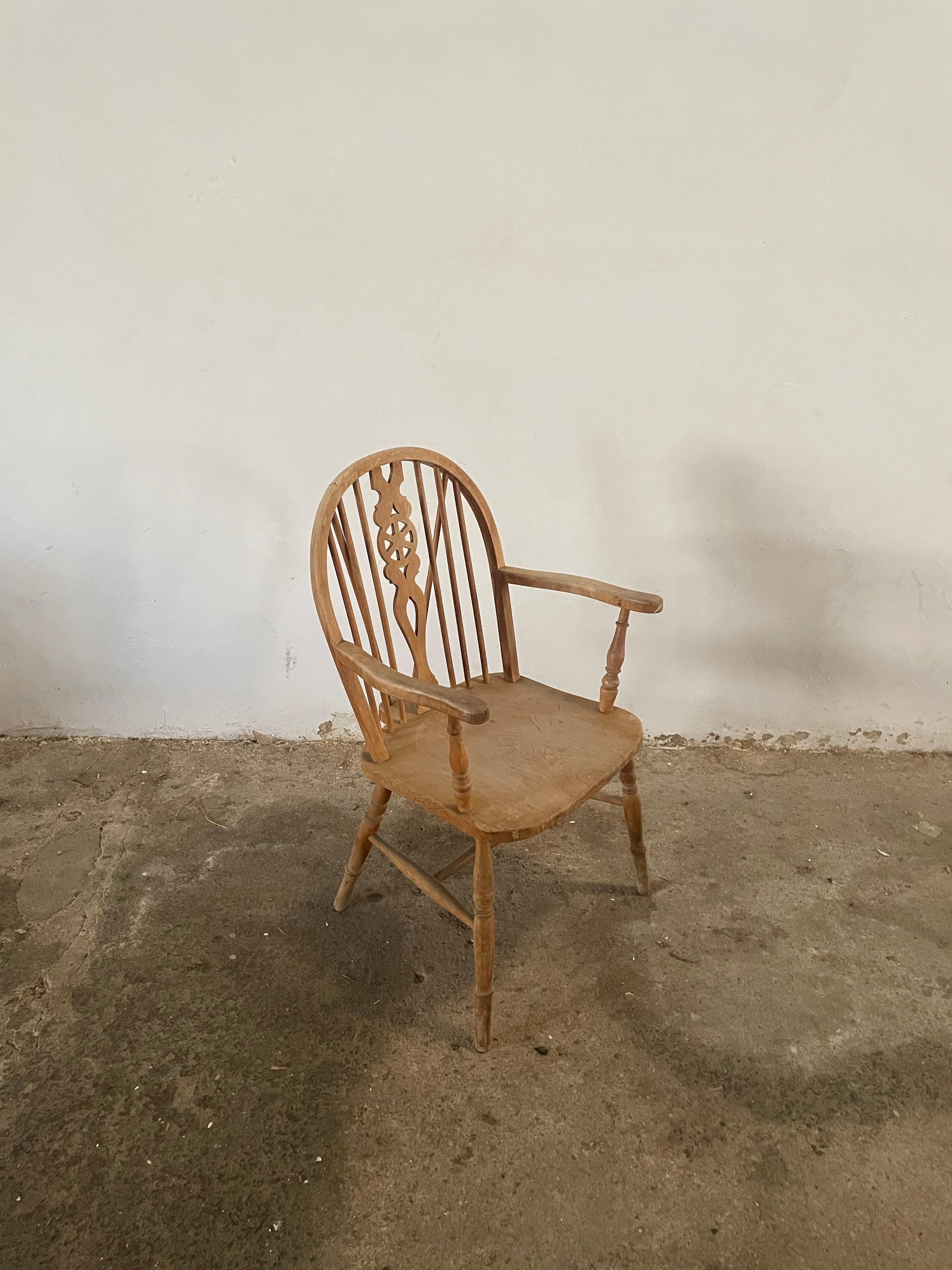 This exceptional Thames Valley Windsor wheelback armchair, circa the early 1800s, presents a rare opportunity to own an authentic piece of English furniture history in remarkable original condition. The chair showcases its natural, untouched frame,