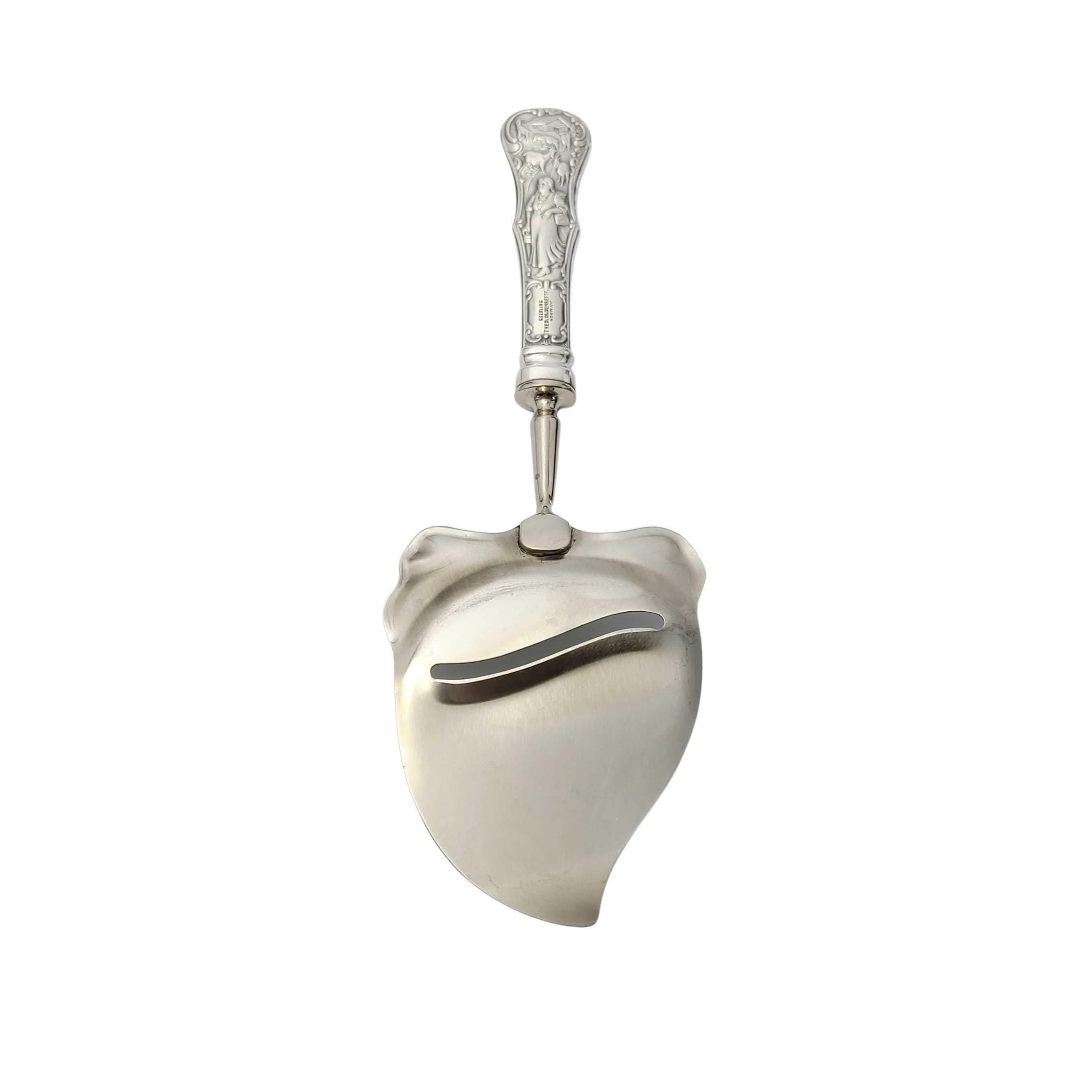 Antiguo cortador de queso de plata de ley de Theodor Olsen Noruega.

Asa repujada que representa a una lechera en una granja. Corta a través del centro de la hoja.

Mide aproximadamente 8 1/2