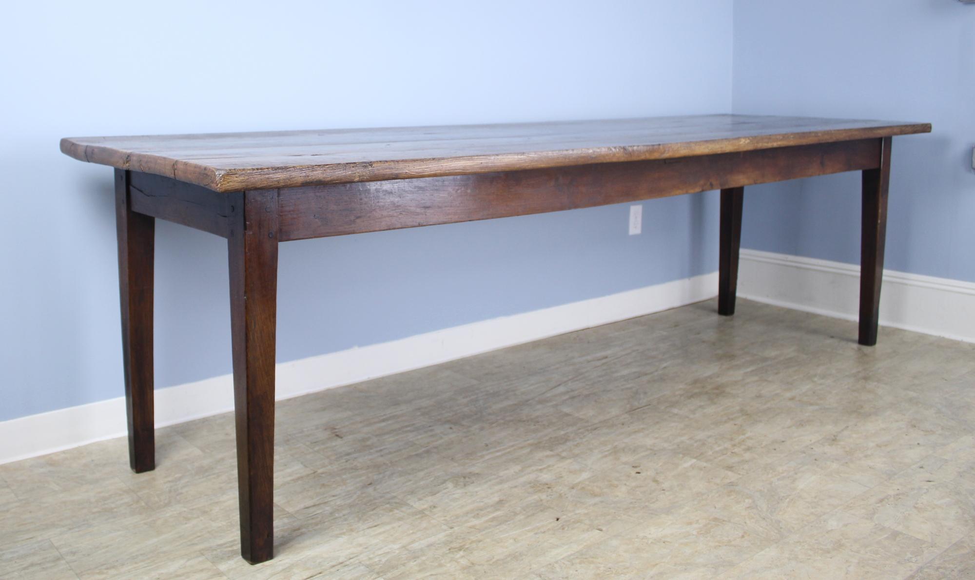 A sturdy and handsome long French ash farm table with classic tapered legs and a chunky thick top. The color and grain on this table are lovely, as is the patina and shine. The 24.5 inch apron height is good for knees. 91.5 inches between the legs
