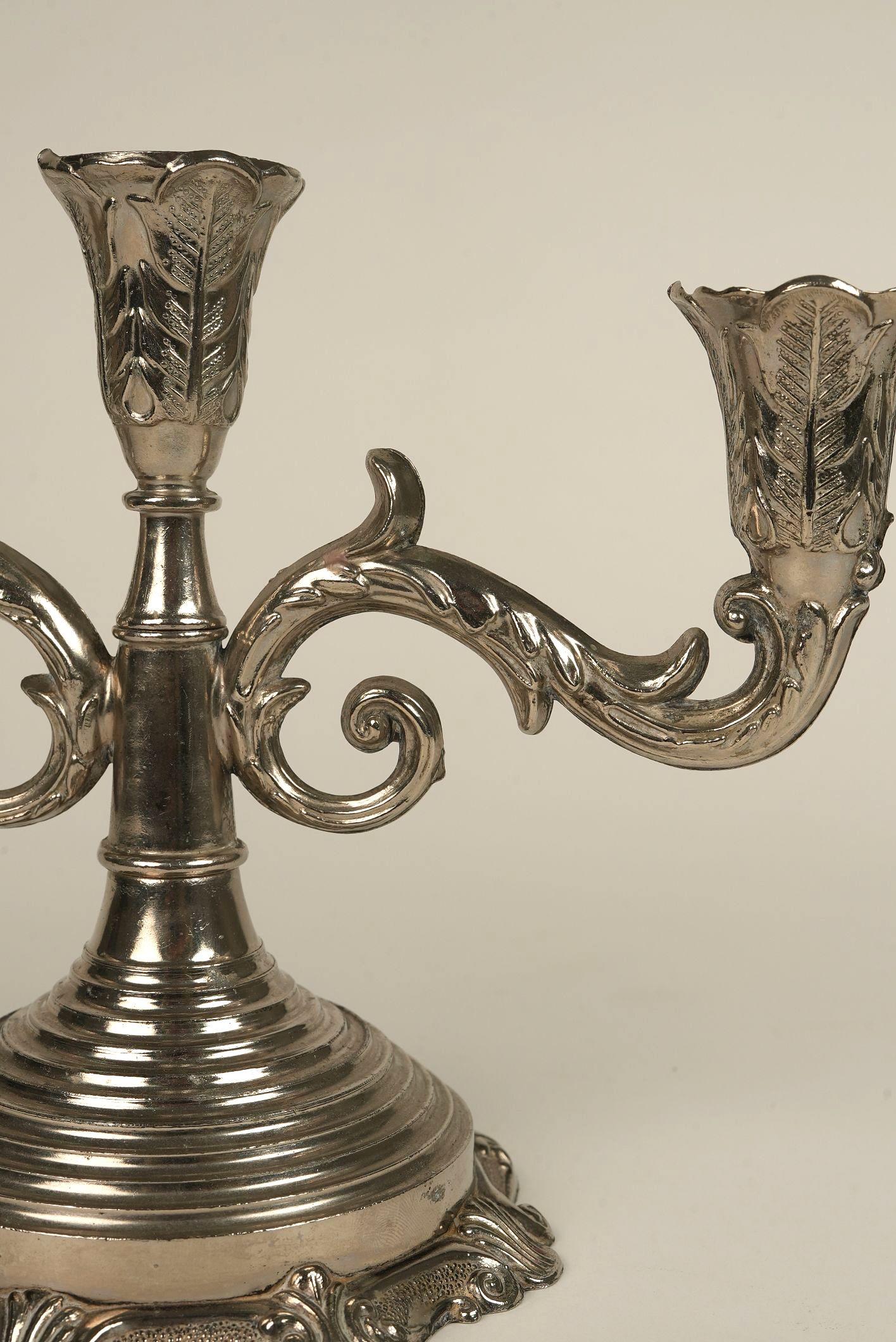 This ornate three-arm antique candelabra is a stunning example of Rococo Revival design — a celebration of opulence, movement, and flourish. Each of the three candle cups is shaped like an unfurling blossom, with finely chased leaf details that
