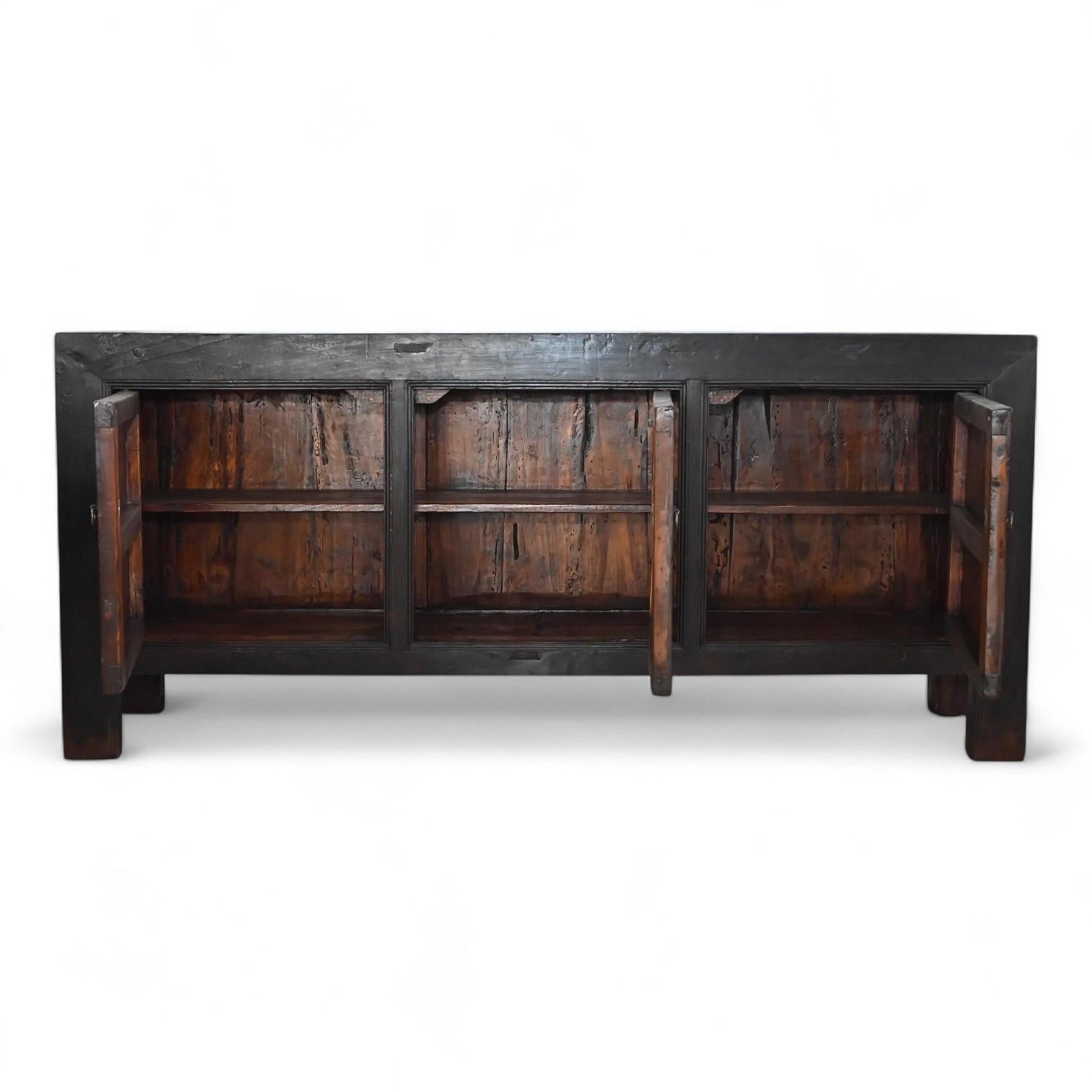 A striking example of early 20th-century Chinese craftsmanship, this three-door sideboard originates from the Shanxi province and is crafted from solid old elm wood over 90 years old. Its minimalist proportions and robust construction embody the