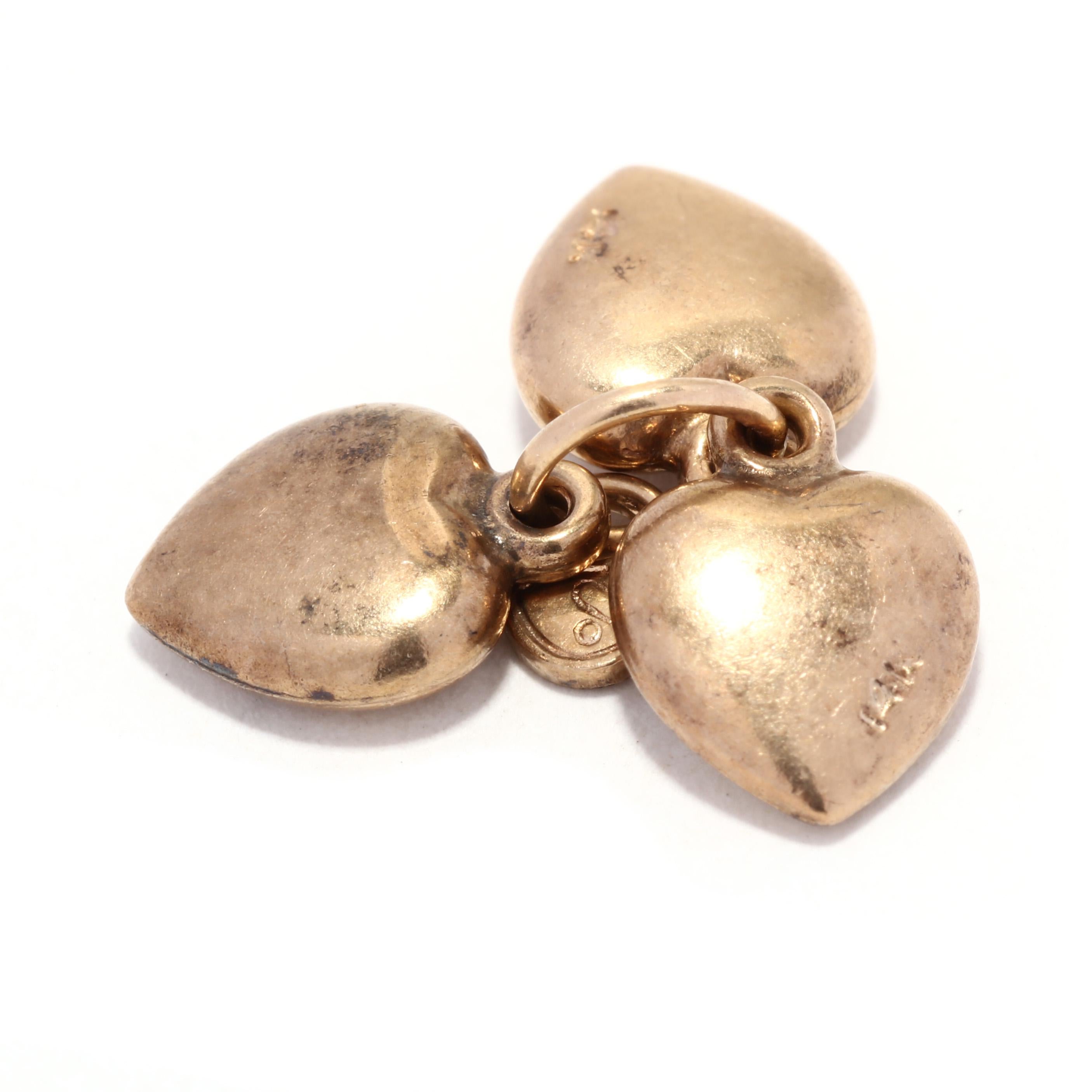 An antique 14 karat yellow gold three heart charm. This small gold charm features three small puff hearts suspended from a single ring with tiny lock motif charm.

Length: 1/2 in.

Weight: 1 dwts. / 1.7 grams

Stamps: 14K

Ring Sizings &