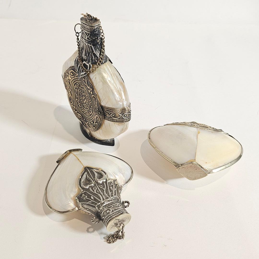 Un set molto unico di 3 antiche bottiglie di profumo/baffi. Realizzato a mano con una bellissima conchiglia, una finitura in madreperla e un'intricata lavorazione dell'argento che formano questo pezzo d'arte. 
In ottime condizioni vintage, ma il