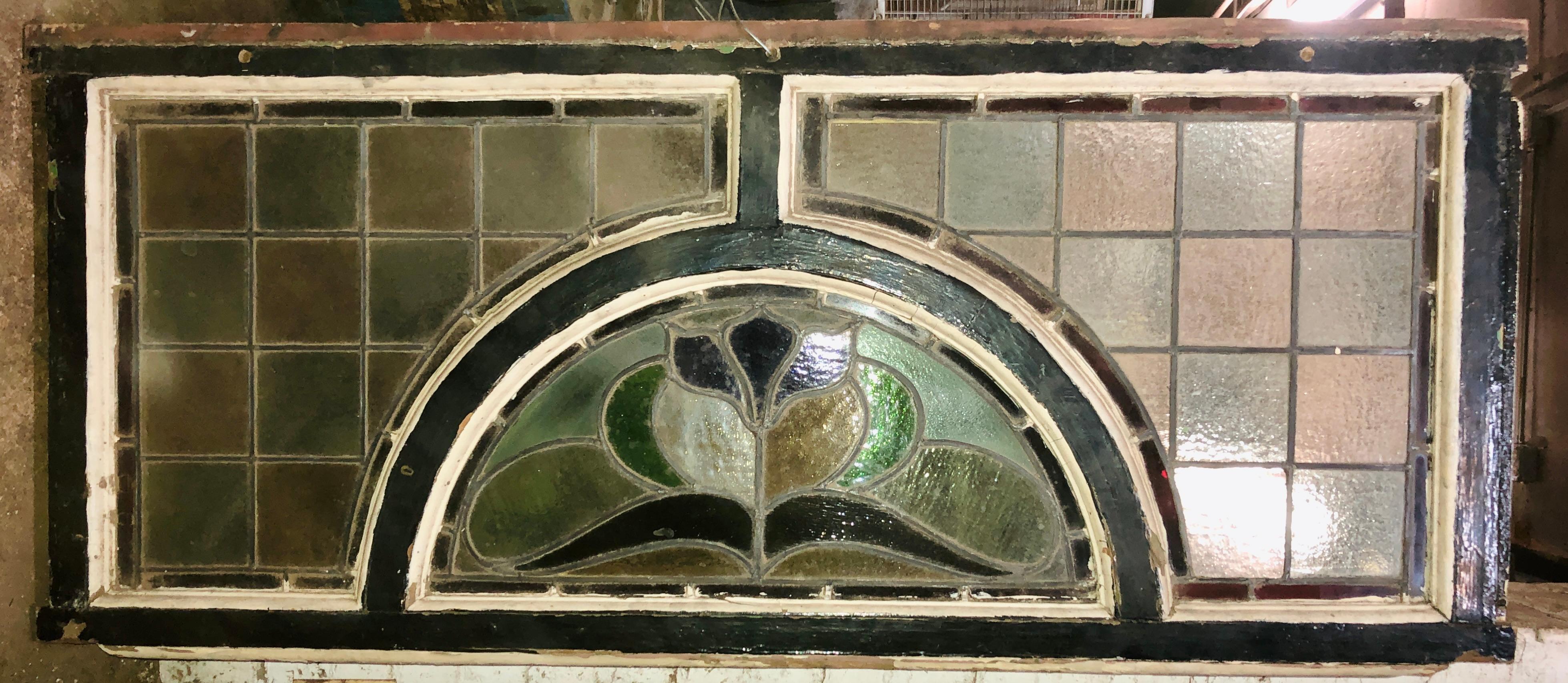 Esta antigua ventana con travesaño procede de una casa de piedra rojiza de Brooklyn situada al borde de Prospect Park. Tres paneles de vidrieras se colocan dentro de este marco de madera gruesa, listos para colgar encima de tu puerta. Dos caras de