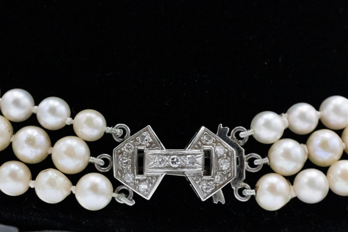 Antique pearl necklace with a platinum clasp and diamonds.

This three-row necklace features 170 cultured saltwater pearls, creamy white with a pink-green hue and very good luster (pearl diameter: 4.80-9.10 mm).

The necklace is finished with a