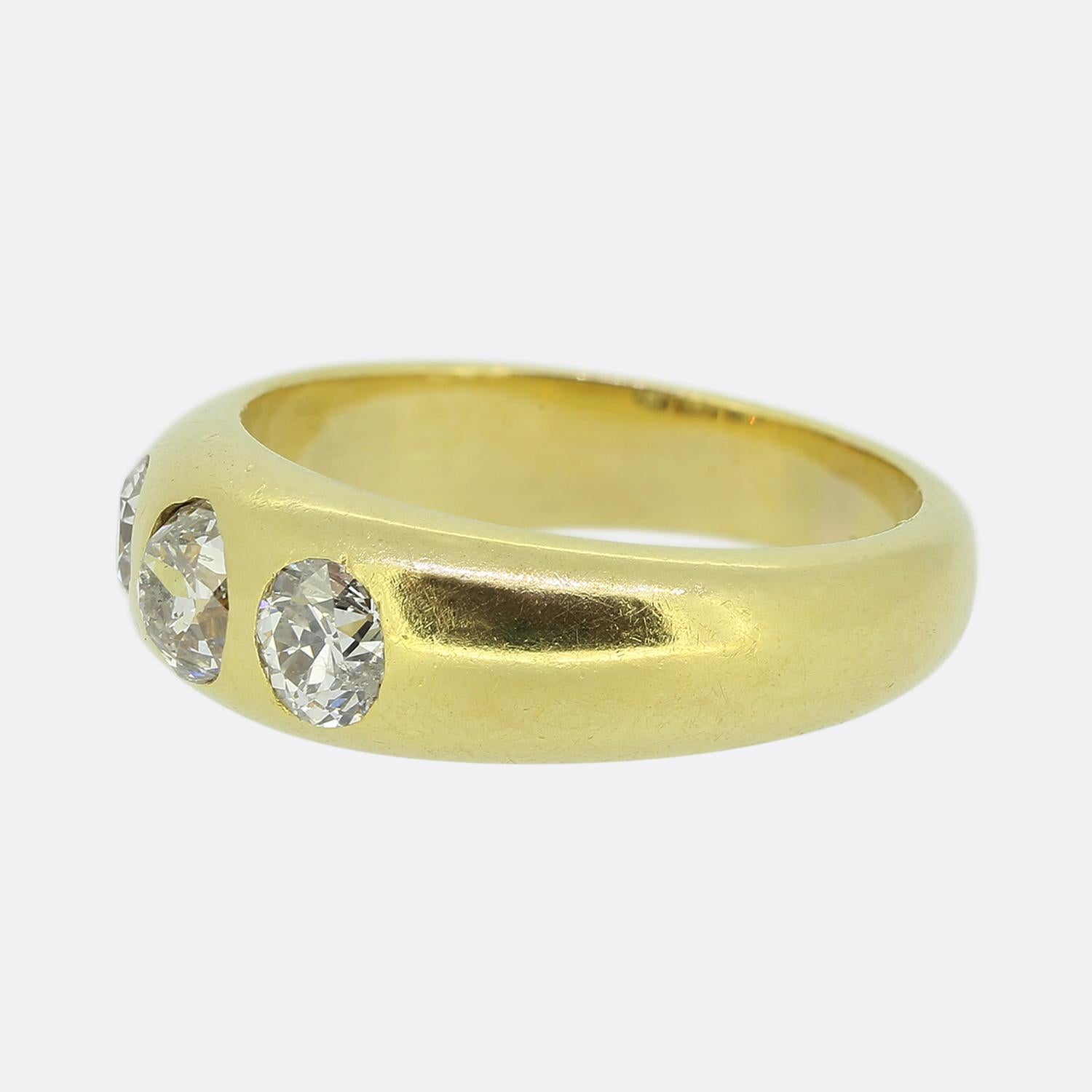 Hier haben wir einen klassisch gestalteten Diamantring mit drei Steinen. Dieses antike Stück wurde aus warmem 18-karätigem Gelbgold gefertigt und verfügt über drei runde, facettierte Diamanten im Altschliff, von denen der größte in der Mitte sitzt.