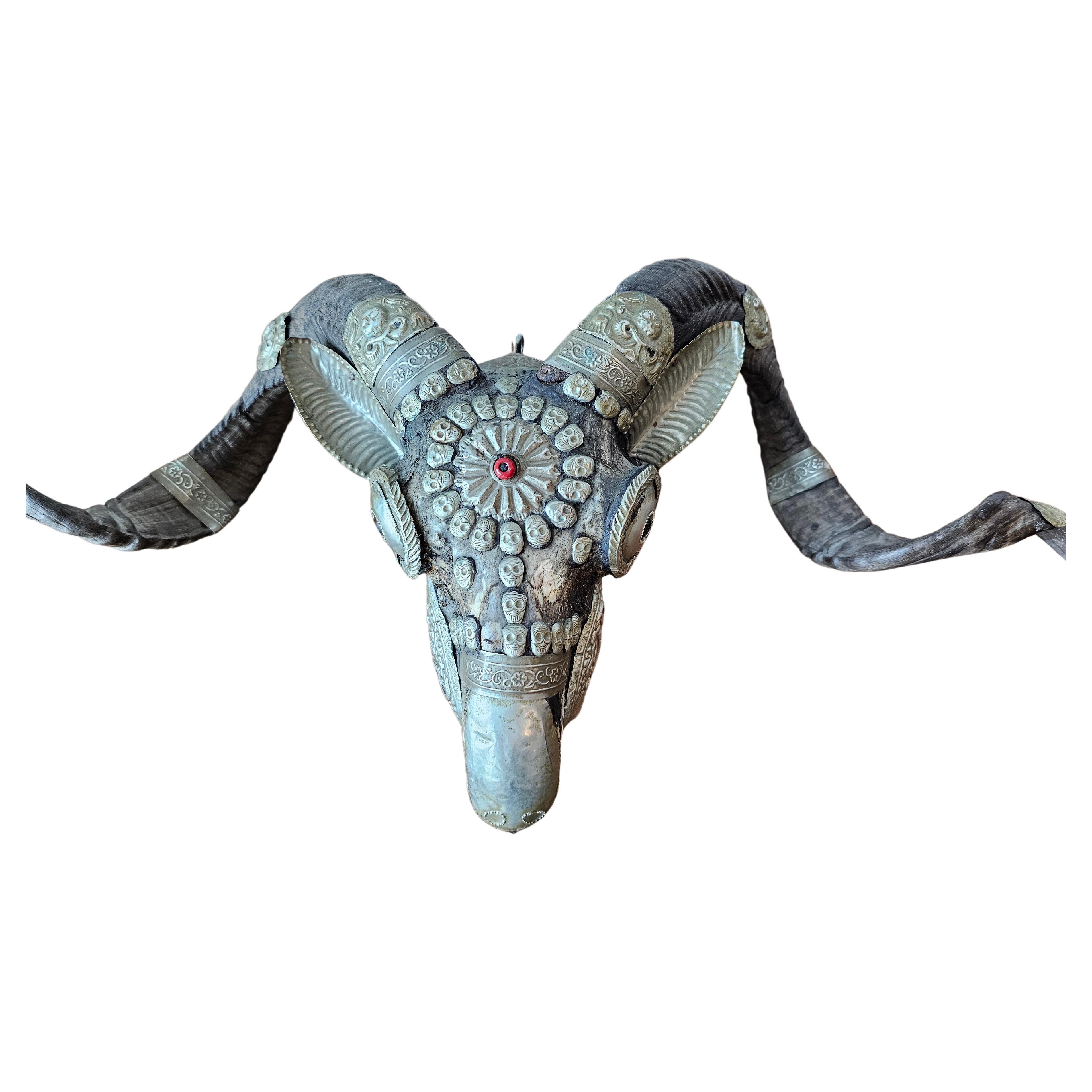 An exceptional antique Tibetan Buddhist monastery ritual / ceremonial goat skull and horn kapala.

Tibet, 19th century, used in shamanic Buddhist Tantra, hand-crafted from a real horned cashmere goat skull, elaborately mounted with repousse silver