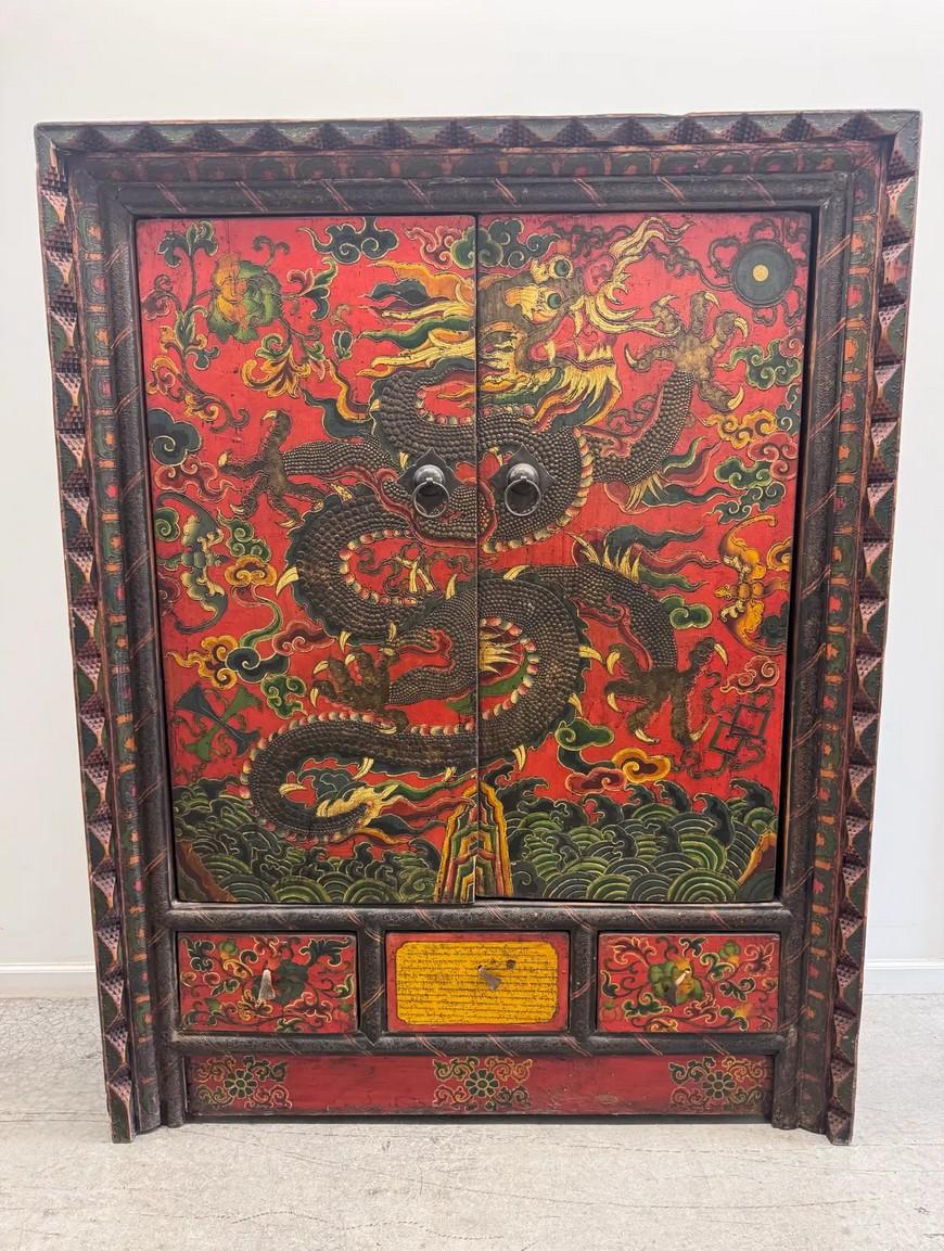 Un superbe et authentique cabinet d'autel tibétain ancien peint à la main avec un dragon à cinq griffes entouré de nuages et de flammes, un puissant symbole impérial représentant la force, la prospérité et la protection.

Cette pièce remarquable a