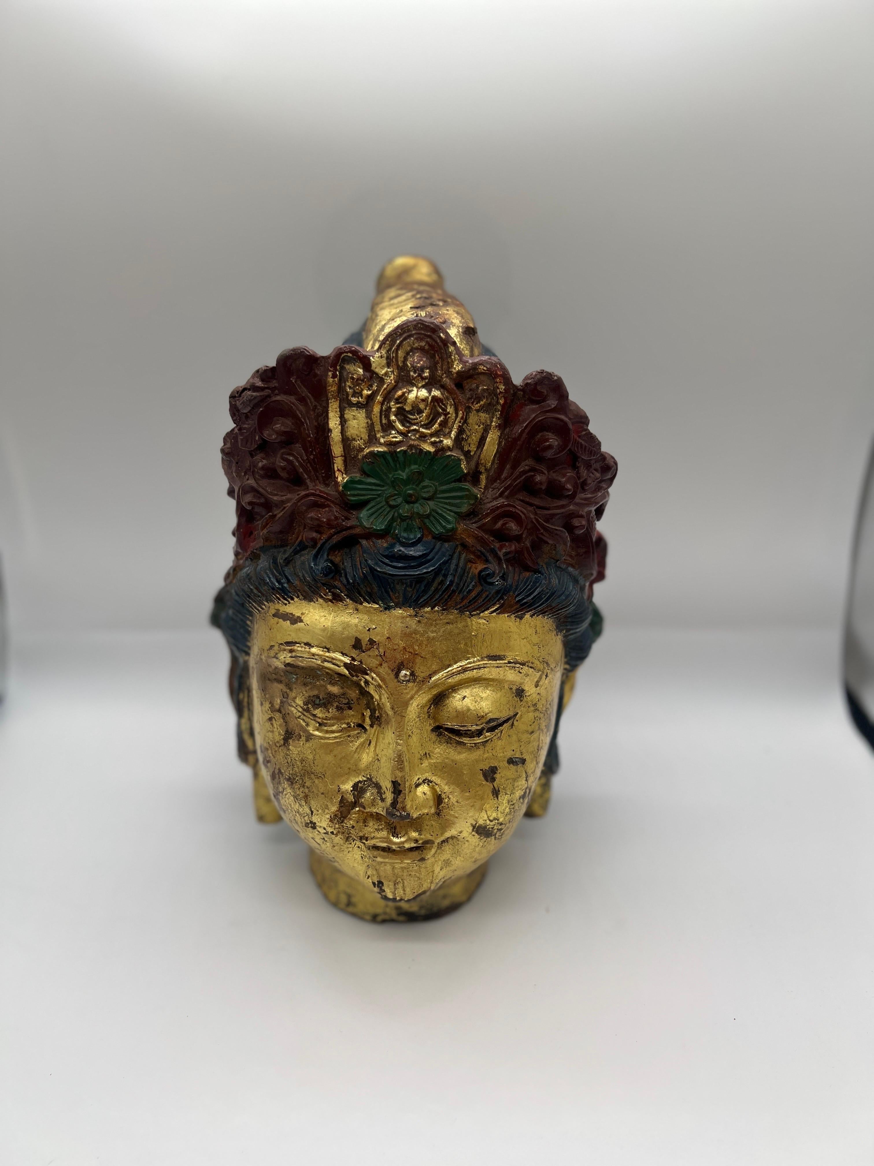 Tibet, 19th century or earlier. 
A heavy and large scale buddha head made of cast iron. The head features antique gold leaf surface and some old polychrome paint (some paint appears to be added).