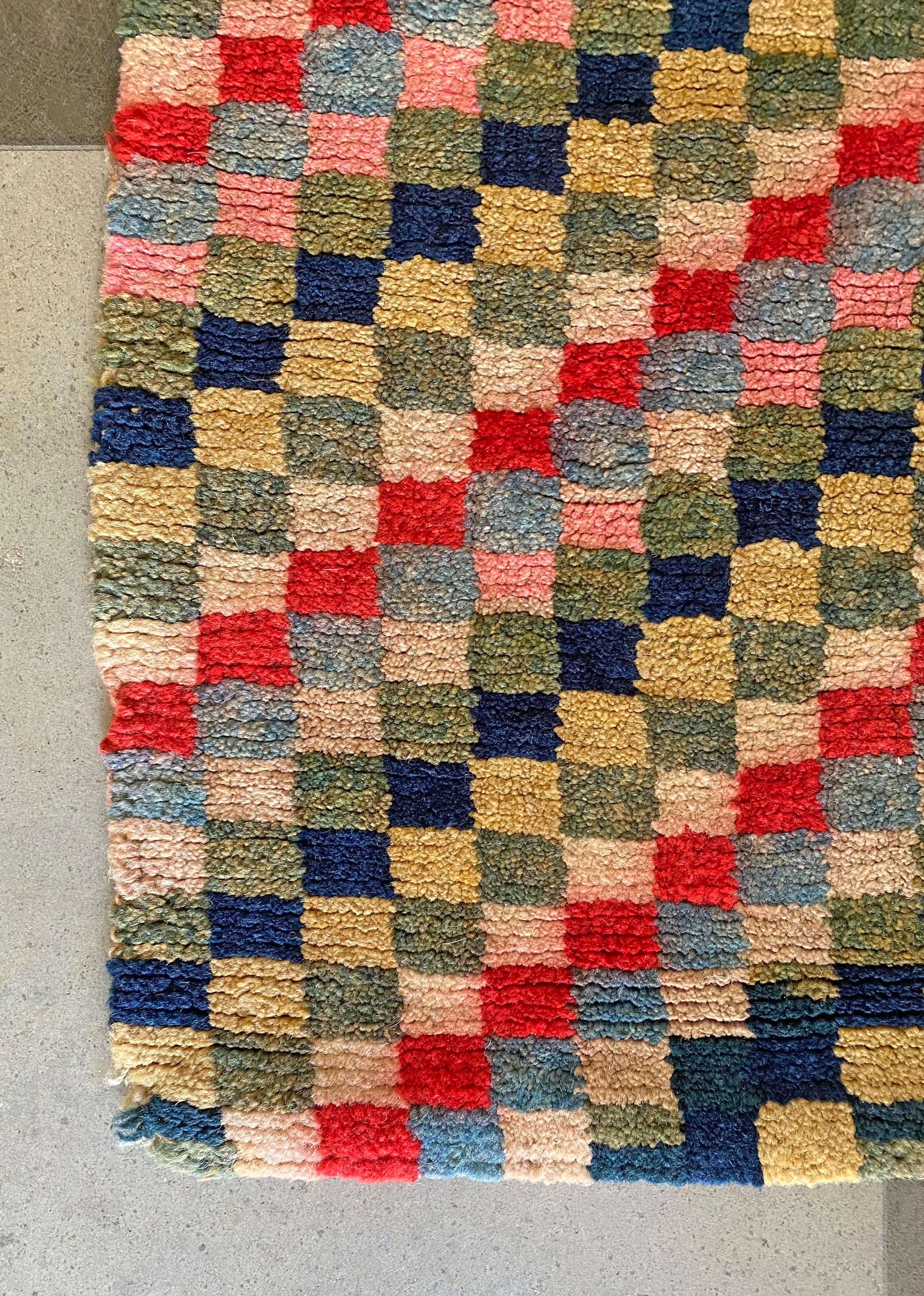 This Checkerboard meditation rug originates from Tibet and dates to the early part of the 20th century. It is hand-knotted and crafted from naturally dyed wool from the highlands of Tibet. The rug was composed using a stunning mix of coloured