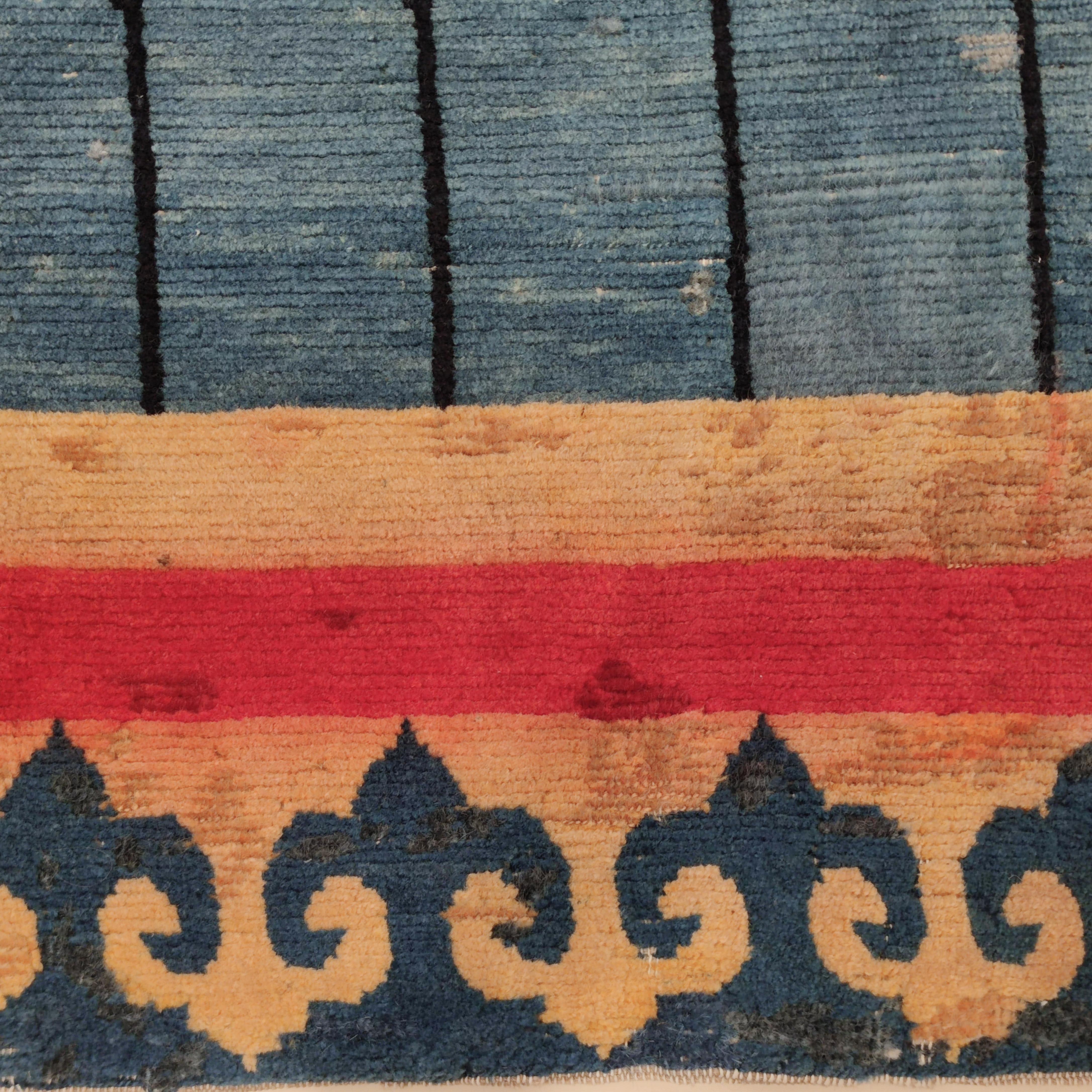 Ein äußerst seltenes Exemplar eines tibetischen Türteppichs, der so genannt wird, weil das Muster genau die gleichen Motive nachahmt, die auf den Seiden- und Baumwollbrokaten zu finden sind, die manchmal die Fassaden der traditionellen tibetischen