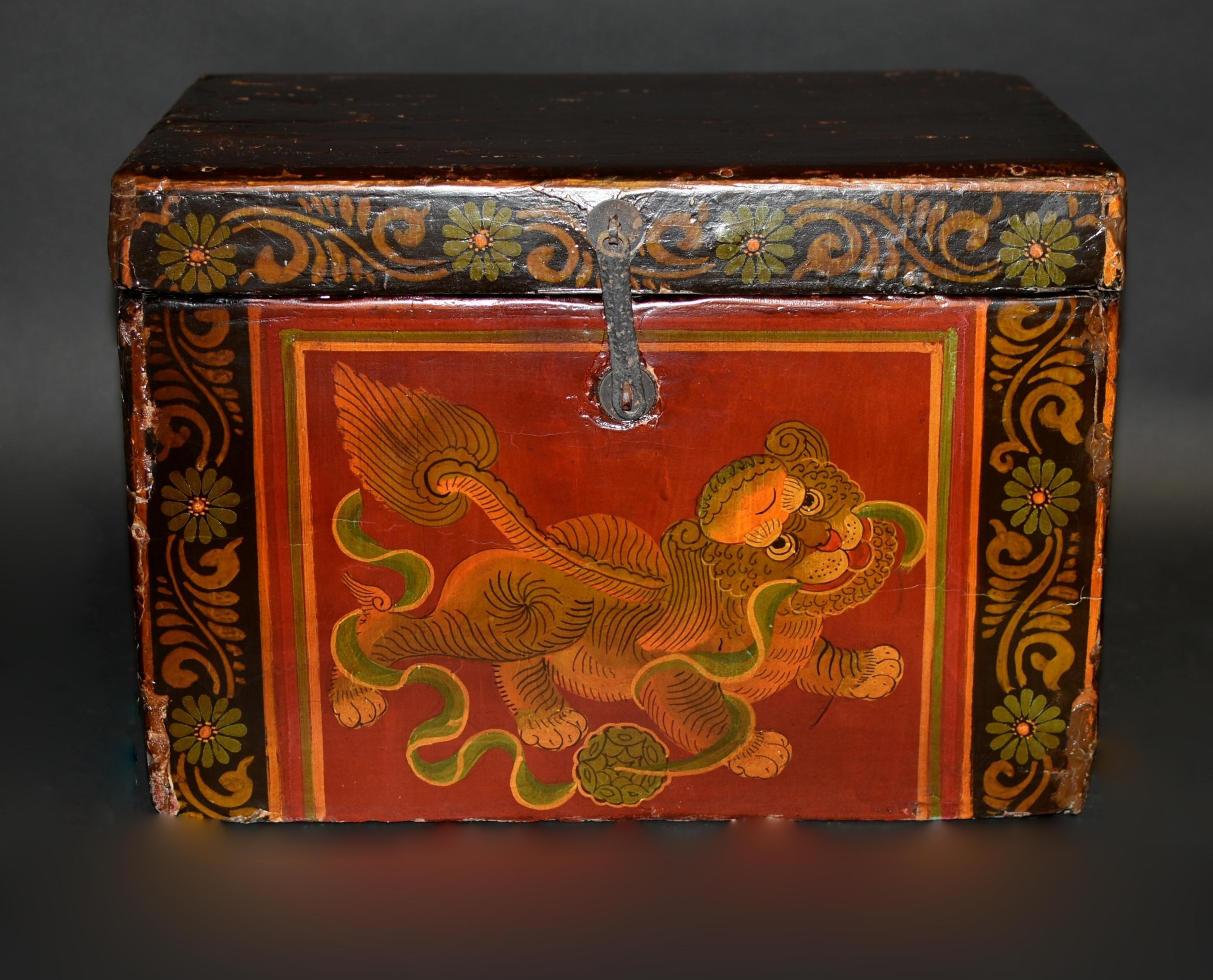 One of our most adorable foo dogs among our limited antique 19th century foo dog box collection. The large head with big innocent eyes and red lips is framed by curled mane. Fleshy paws pressing into the ground, with a wavy green ribbon wrapped