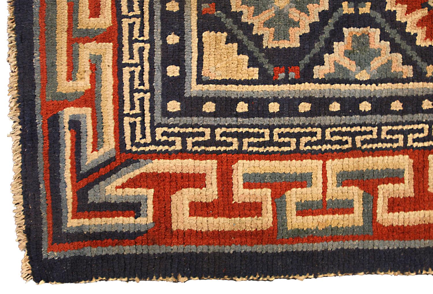 This is an antique Tibetan mat rug woven during the first quarter of the 20th-century circle 1920 and measures 80 x 66CM in size. its field is made using a lattice design accompanied with repeating abstract snowflake motifs set on a dark blue
