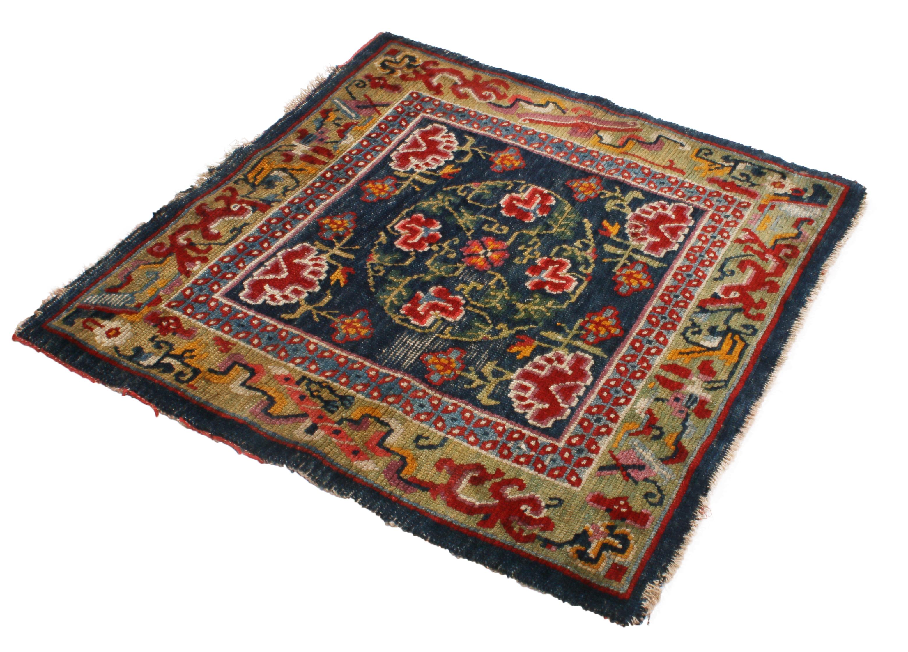 Originating from Nepal in 1910, this antique Tibetan wool rug hosts a variety of curvilinear geometric-floral symbols embodying influences from Chinese Peking and Art Deco pieces. Hand knotted with durable wool pile, the grand green and pink floral