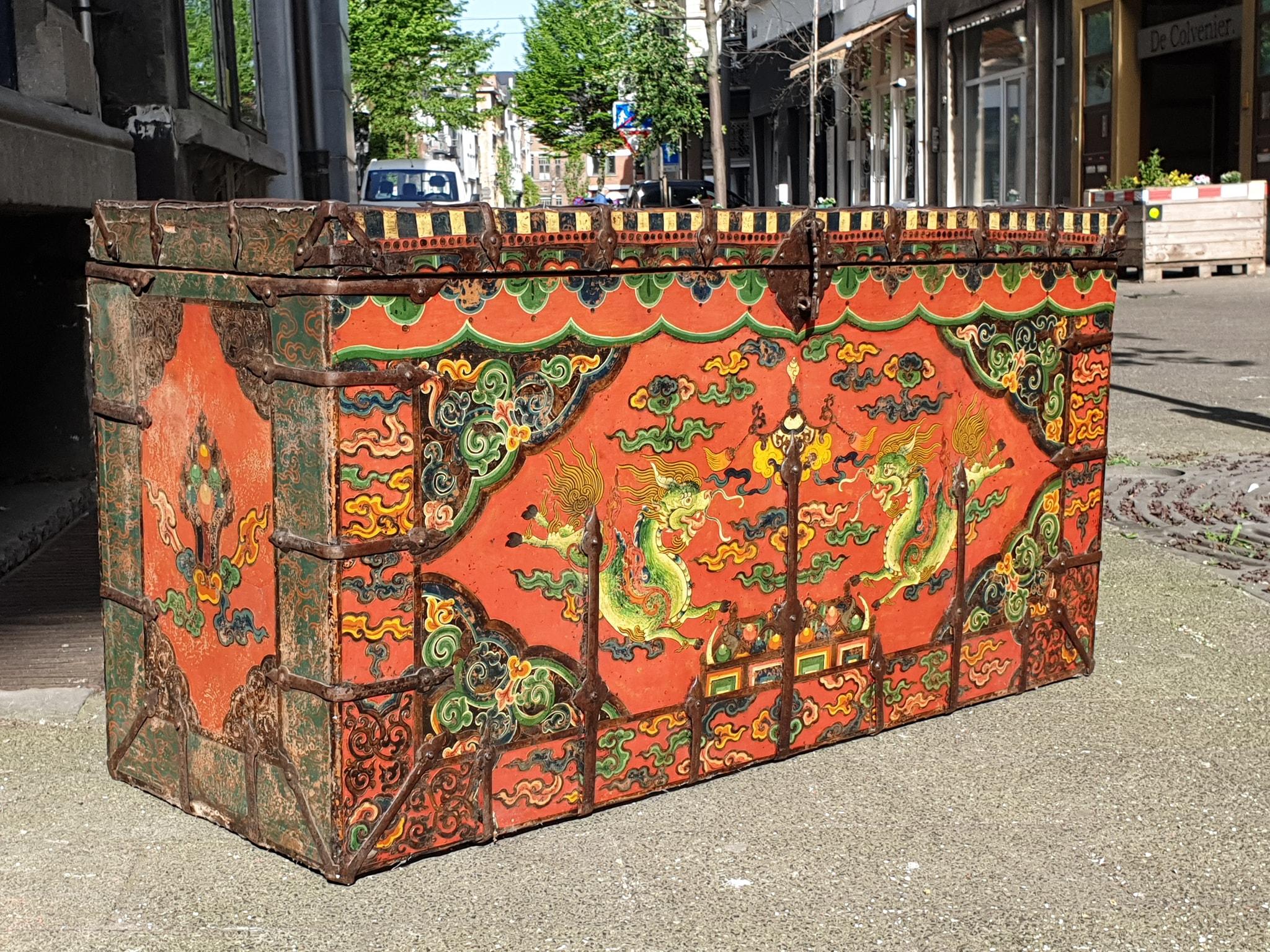 A charming Tibetan-Chinese painted storage trunk, 18th century, Tibet.  

In red paint.The front with hand-painted decoration depicting two central dragons among scrolled clouds. The border painted with symbols.The hardware of rustic, hand-forged