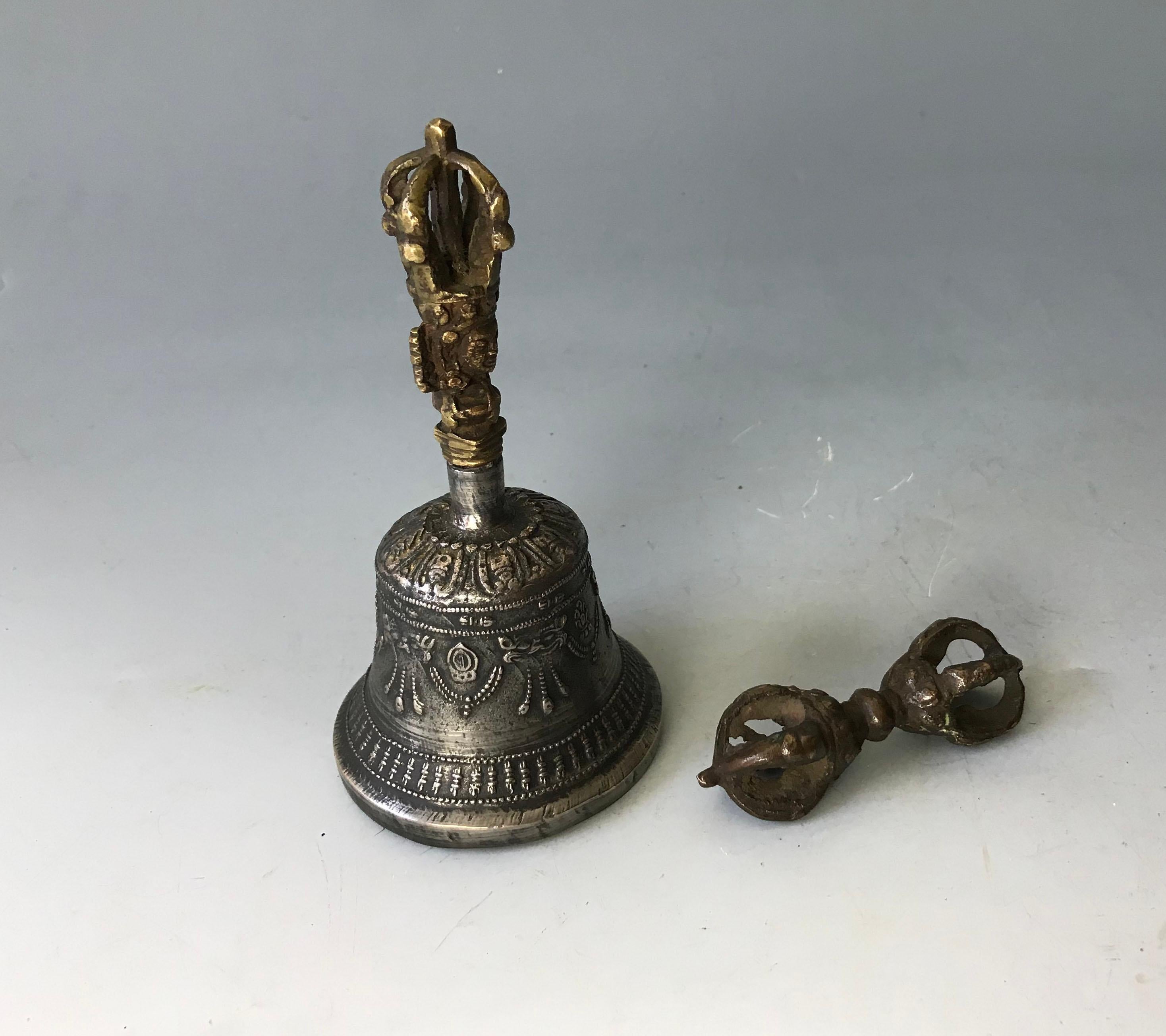 Ensemble rituel tibétain antique Ghanta Bell avec Vajra/Dorje 
La cloche avec poignée en bronze doré avec la tête de Prajna Paramita et un petit dorje très ancien datant du 18ème siècle.
La cloche et le dorje sont utilisés pour accomplir un rituel