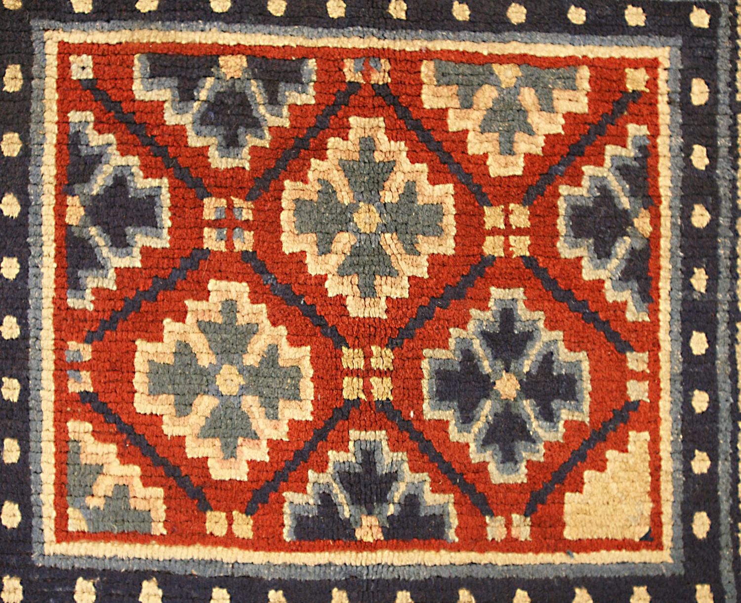 This is an antique Tibetan mat rug woven during the beginning of the 20th century circa 1900-1920 and measures 81x 68CM in size. its field is comprised of lattice design using geometric motifs which represent snowflakes set on a red background