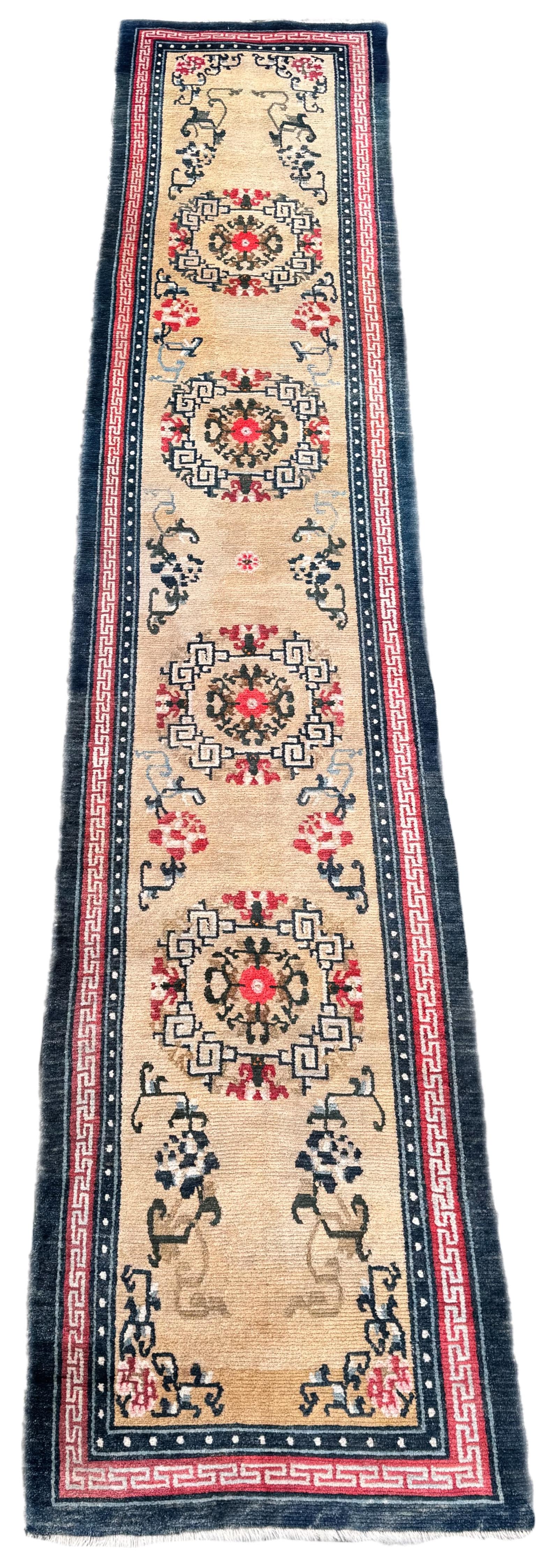 Un chemin de table inhabituel, tissé au Tibet vers 1910. Le motif présente quatre médaillons circulaires sur un champ ivoire doux, entouré d'une bordure simple en terre cuite et d'une bordure extérieure bleu marine.
Taille : 4,03m x 0,81m (13ft 3in