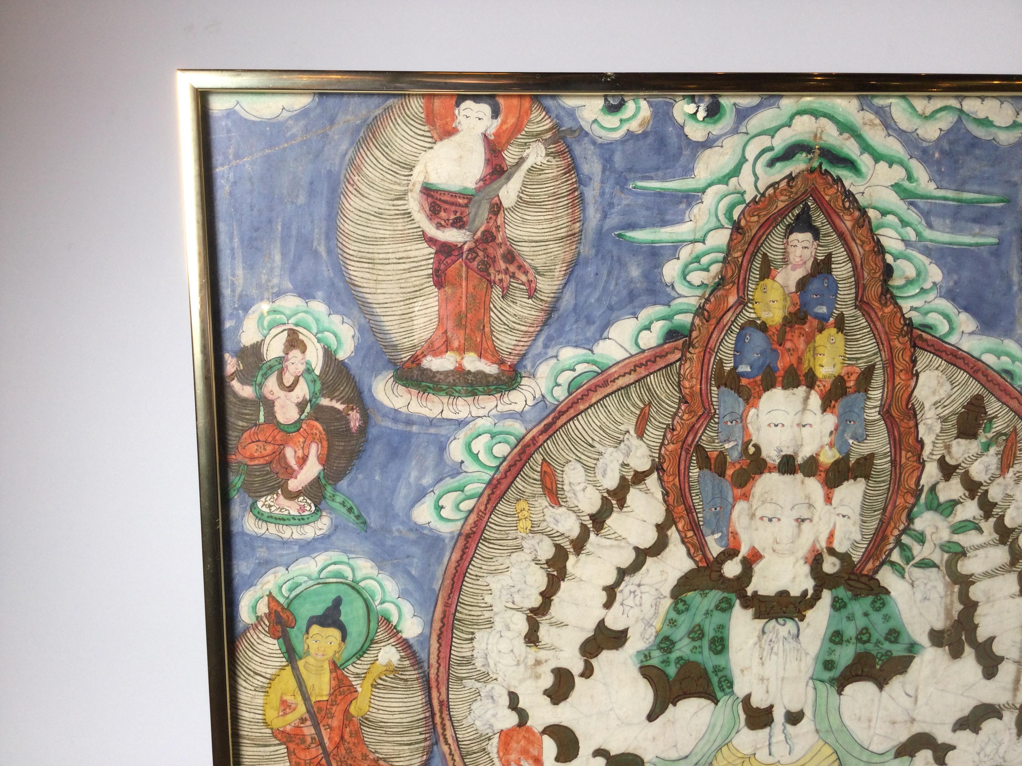 A vibrantly colored Tibetan Thangka of a multi armed Deity, Tibet Circa 1900, framed in a gold tone frame under glass, Measures: 28 inches tall, 30.75 inches wide.