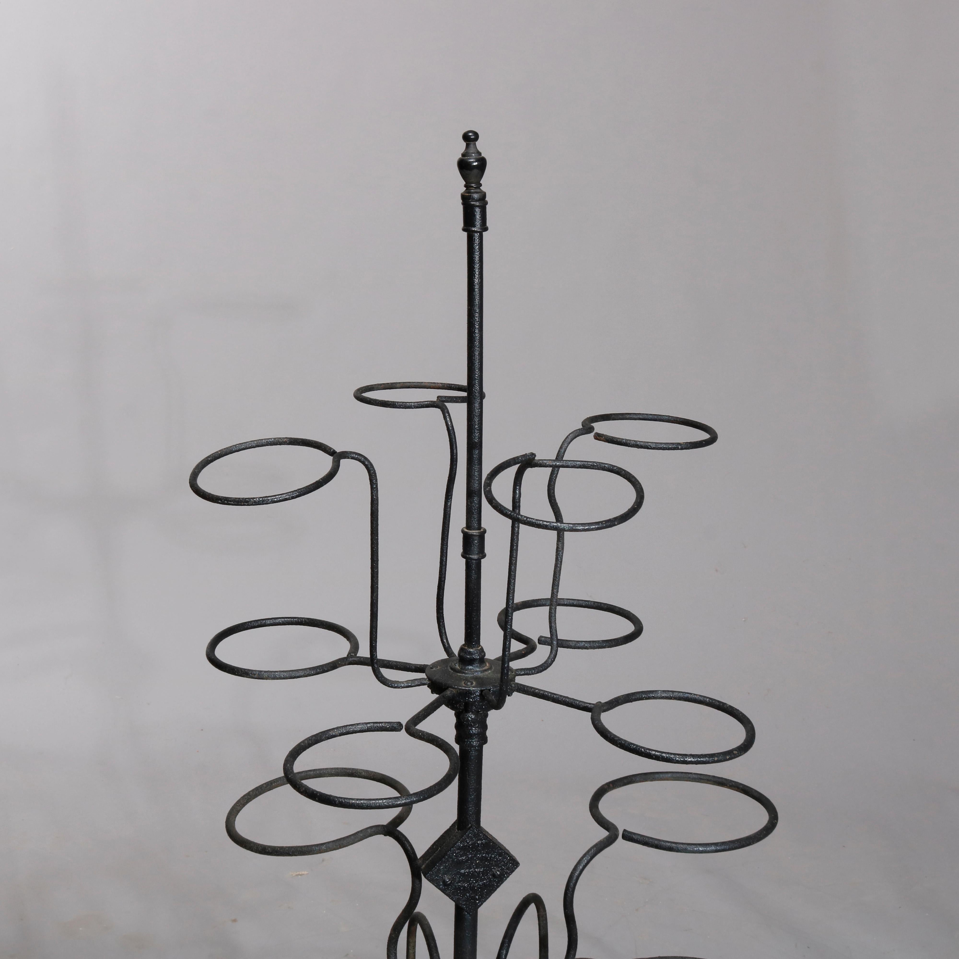 An antique garden plant display stand offers wrought iron construction with tiered scrolled arms terminating in pot receivers, raised on four legs, circa 1890

Measures: 53.25