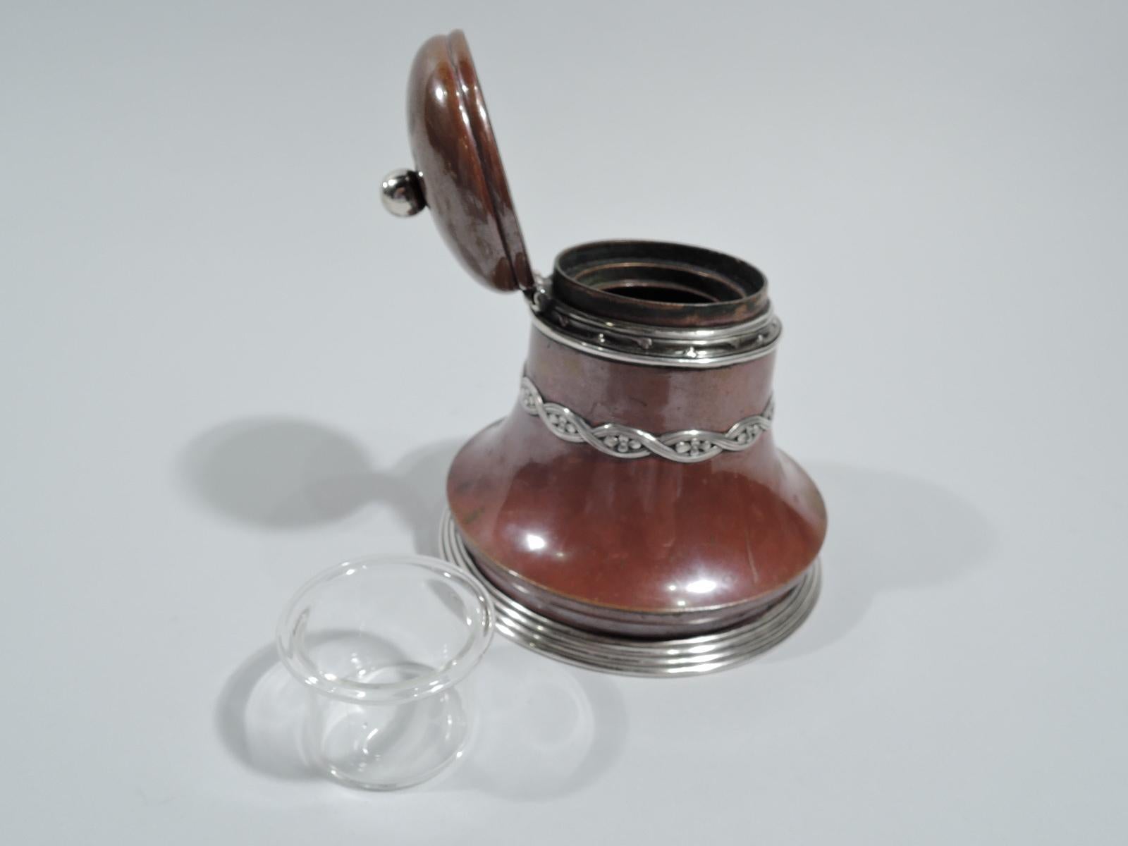 Aesthetic mixed inkwell. Made by Tiffany & Co. in New York. Bell-form copper body with reeded silver foot rim. Applied silver ornament including flower-inset guilloche band and tendril border at neck. Cover hinged and domed with silver ball finial.