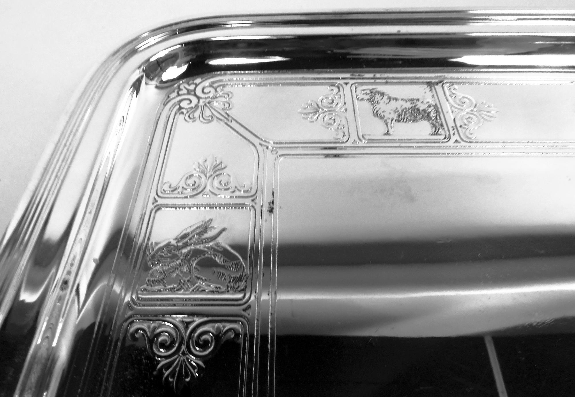 Bandeja de guardería Art Déco de plata de ley. Fabricado por Tiffany & Co. en Nueva York, hacia 1922. Rectangular con esquinas curvadas, hombro plano y estrecho, y borde reed. El pozo tiene un borde grabado al ácido compuesto por marcos rectilíneos