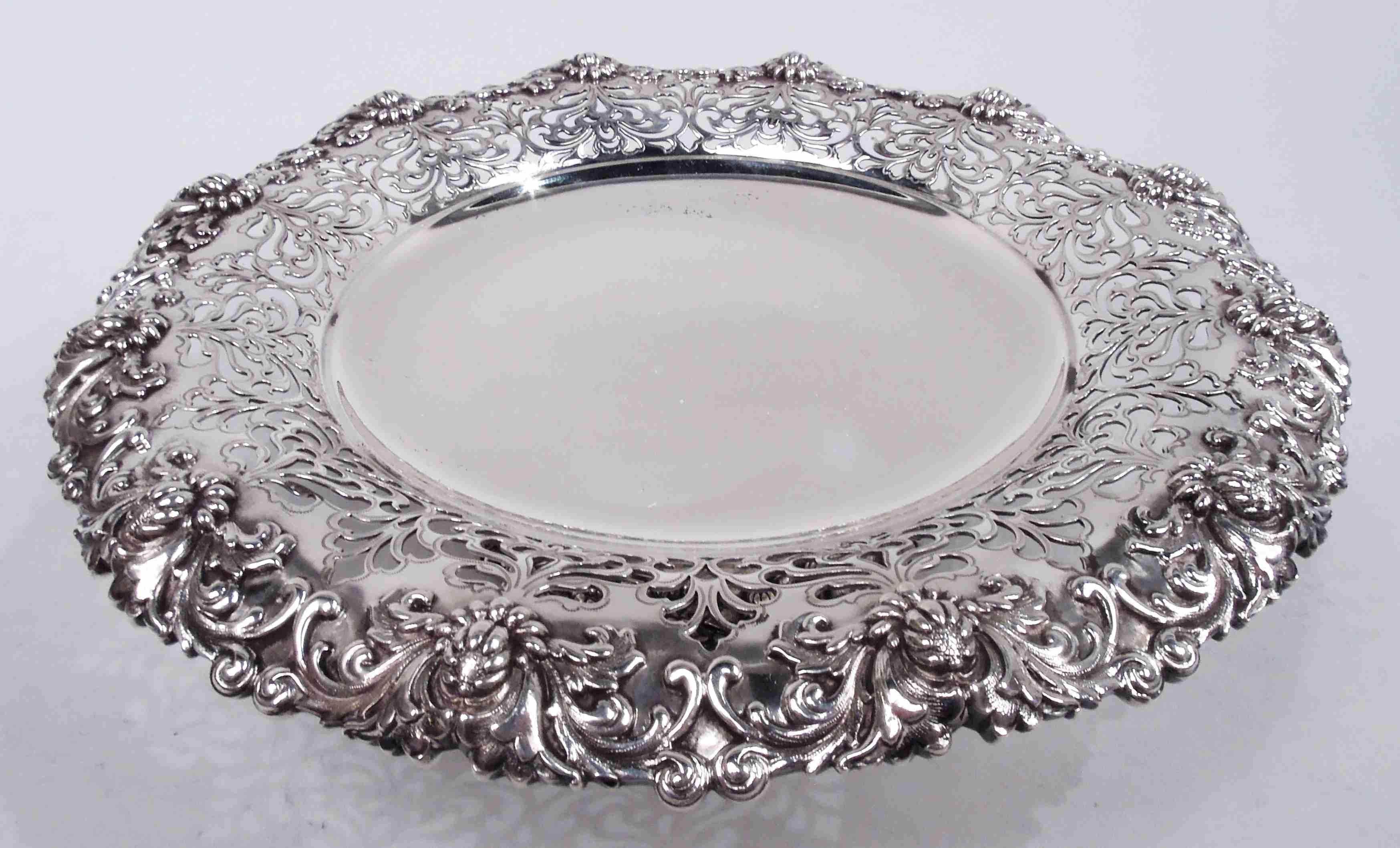Victorian Classical sterling silver compotes. Made by Tiffany & Co. in New York. Each: Round solid well; sides have pierced leafing scrollwork and turned-down rim applied with cast leafing scrollwork and buds that suggest the influence of