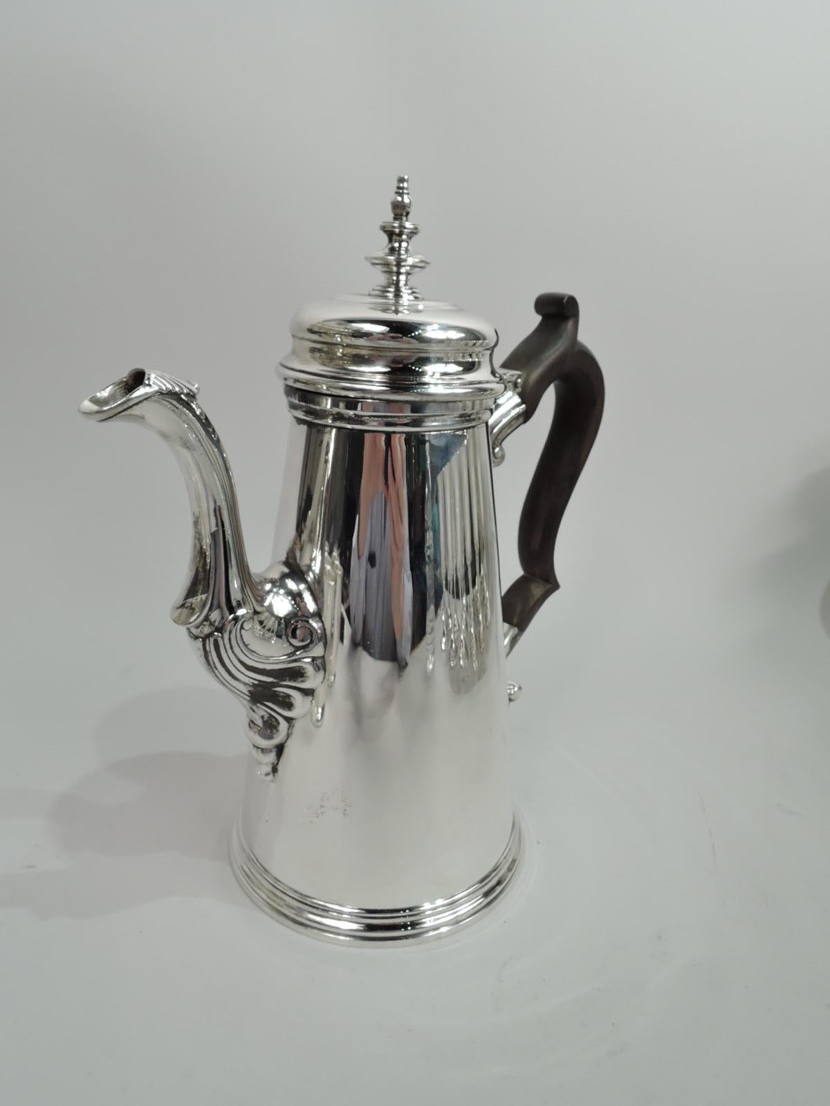 American Colonial sterling silver coffeepot. Made by Tiffany & Co. in New York, ca 1916. Conical with capped and scroll-mounted s-scroll spout. Capped double-scroll handle in stained wood. Cover hinged and domed with finial. Holds 2 1/4 pints. Fully