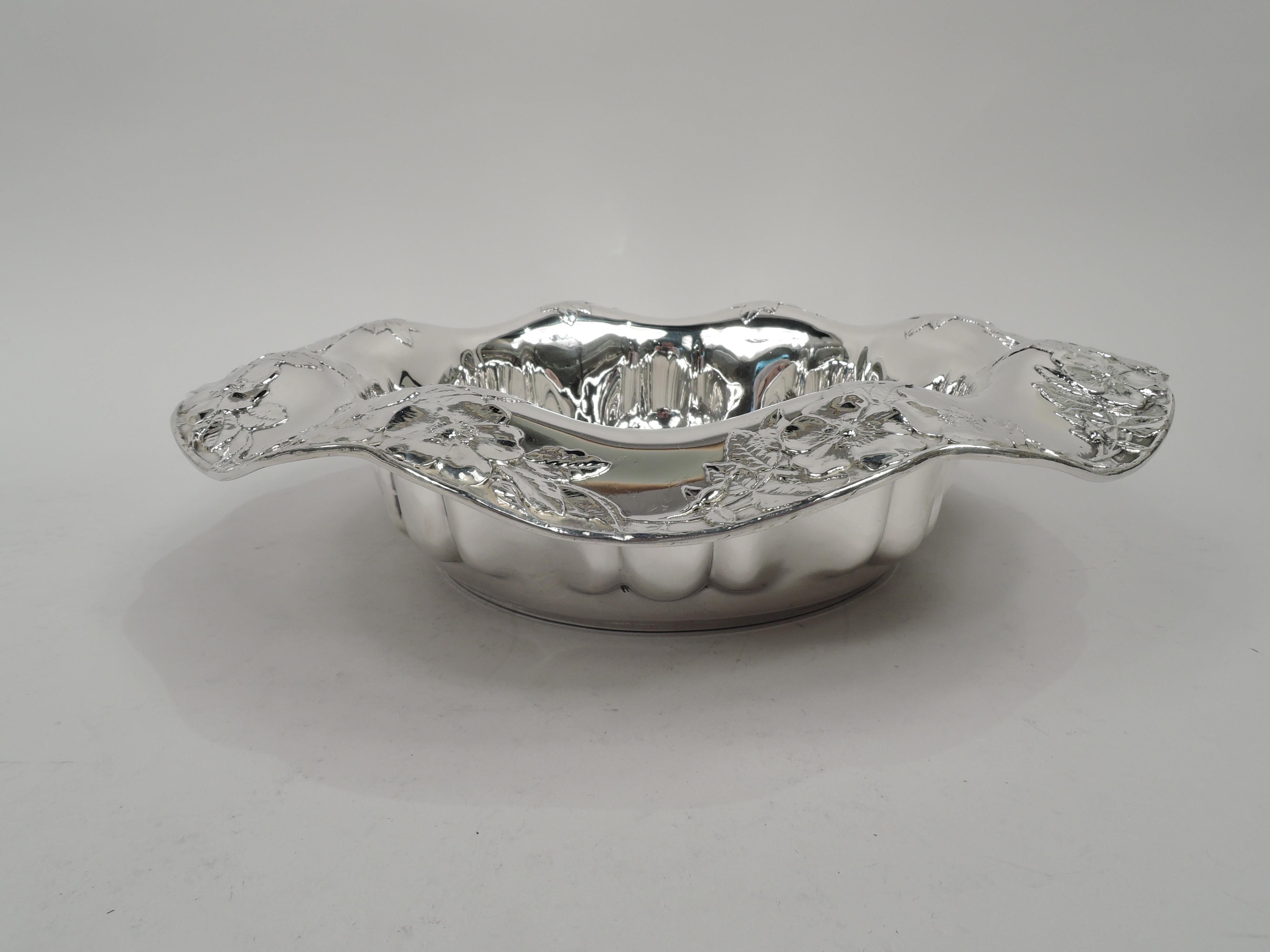 Edwardian Art Nouveau sterling silver bowl. Made by Tiffany & Co. in New York, ca 1910. Round well with embossed abstract egg-and-dart border. Wavy and scalloped rim with applied flowers and leaves. Fully marked including maker’s stamp, pattern no.
