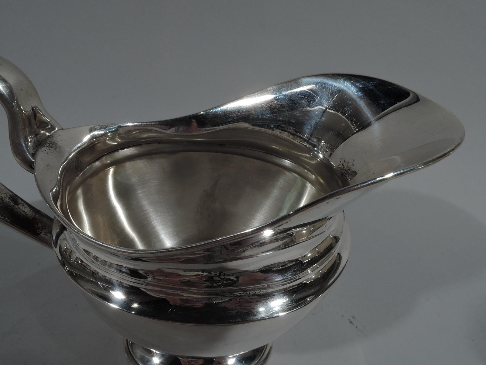 Edwardian classical sterling silver creamer. Made by Tiffany & Co. in New York. Ovoid body with high looping scroll handle, concave shoulder, helmet mouth, and raised foot. Fully marked including pattern no. 15416 (first produced in 1902) and
