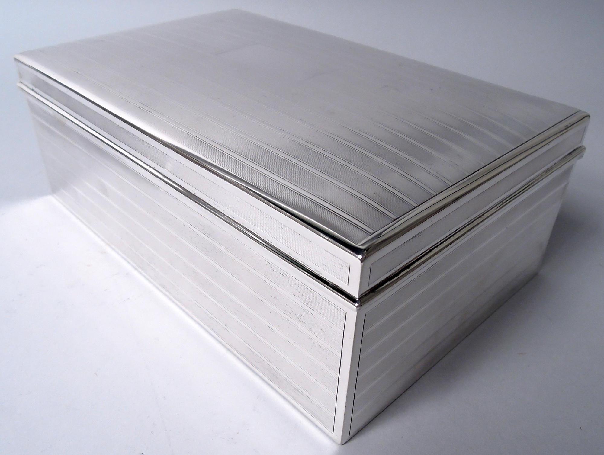 Caja de puros eduardiana de plata de ley. Fabricado por Tiffany & Co. en Nueva York en 1922. Rectangular con lados rectos; tapa abatible con parte superior suavemente curvada. En los laterales, alternancia de bandas lisas y lengüetas en marcos