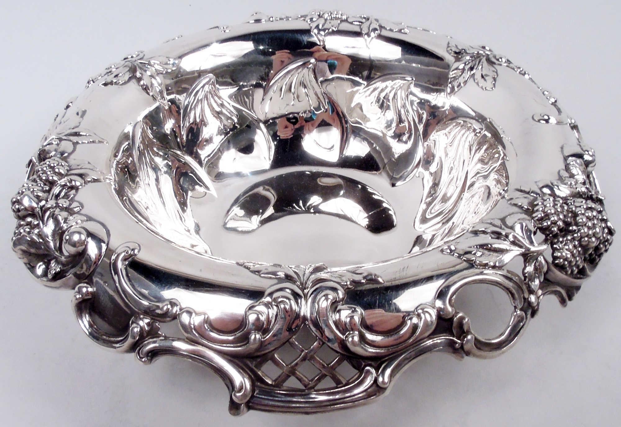 Gilded Age sterling silver blackberry bowl. Made by Tiffany & Co. in New York. Round well; sides tapering with chased outsized leaf border. Scrolled and open turned down rim with applied c-scrolls, leaves, berries, and diaper. A great high-low