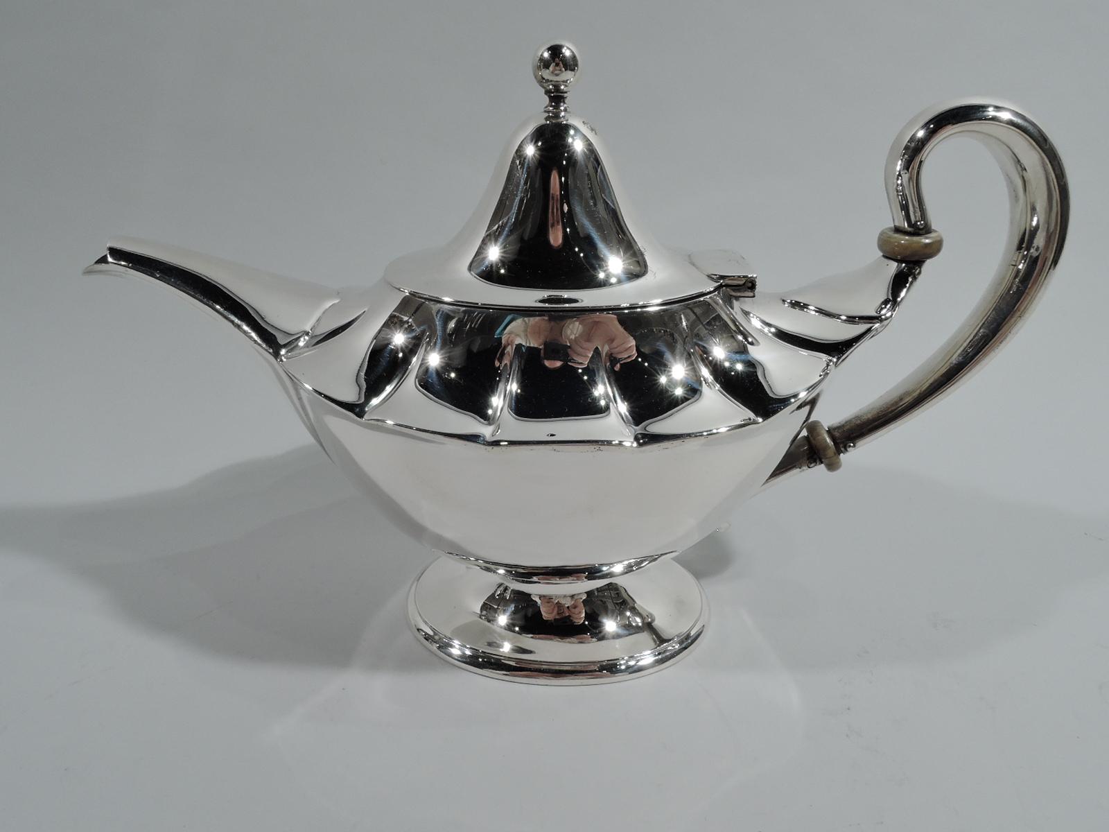 Edwardian Classical sterling silver teapot. Made by Tiffany & Co. in New York. Tapering oval bowl with wide shoulder lobes, high-looping handle, and wide and tapering spout. Cover hinged and domed with ball finial. Raised oval foot. Fully marked