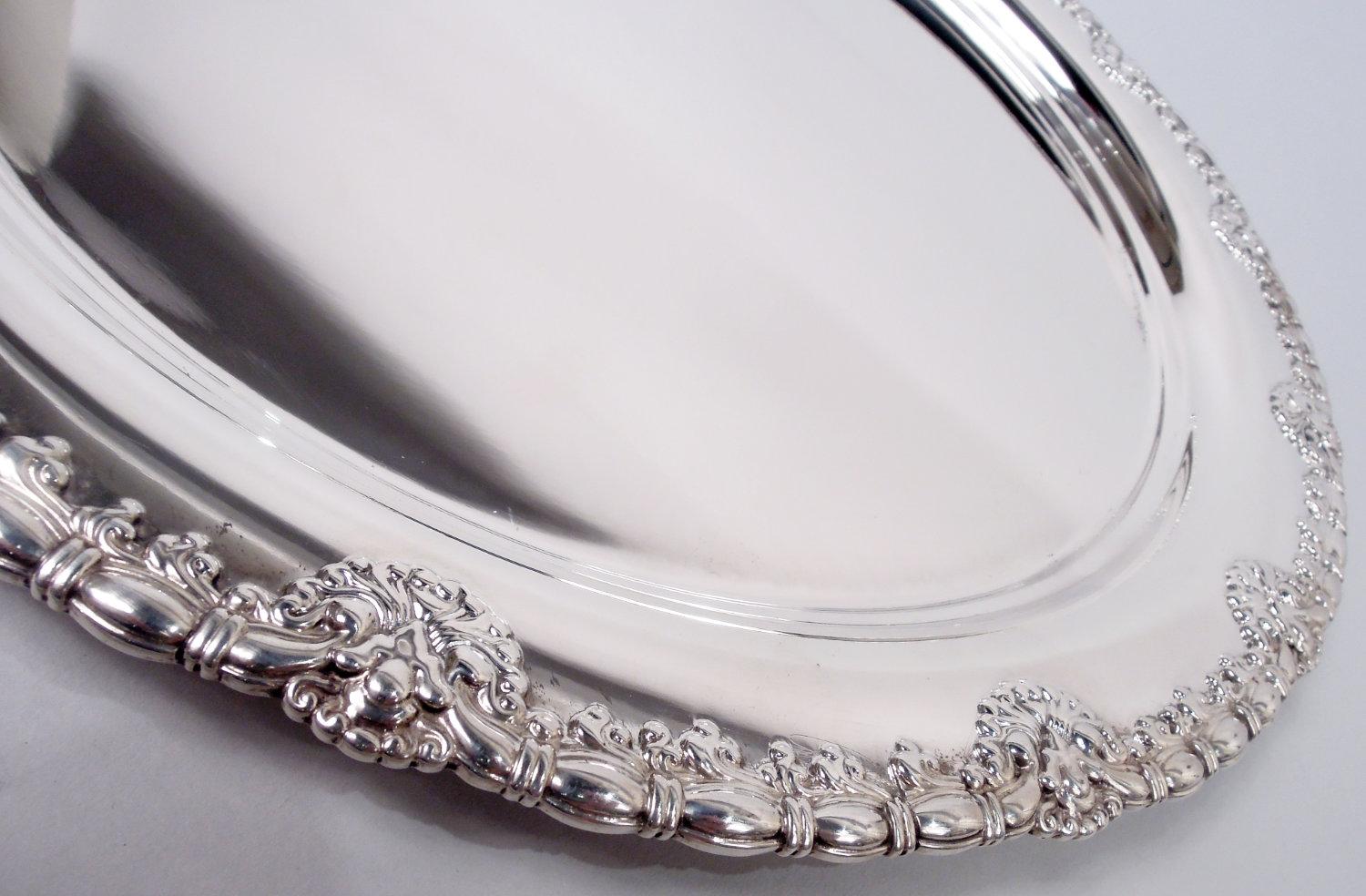 Vassoio in argento Sterling King inglese. Realizzato da Tiffany & Co. a New York. Rotondo con bordo applicato a perline e mulinelli intervallati da conchiglie a smerlo. Completamente marcato con timbro del produttore, modello n. 5765 e lettera del