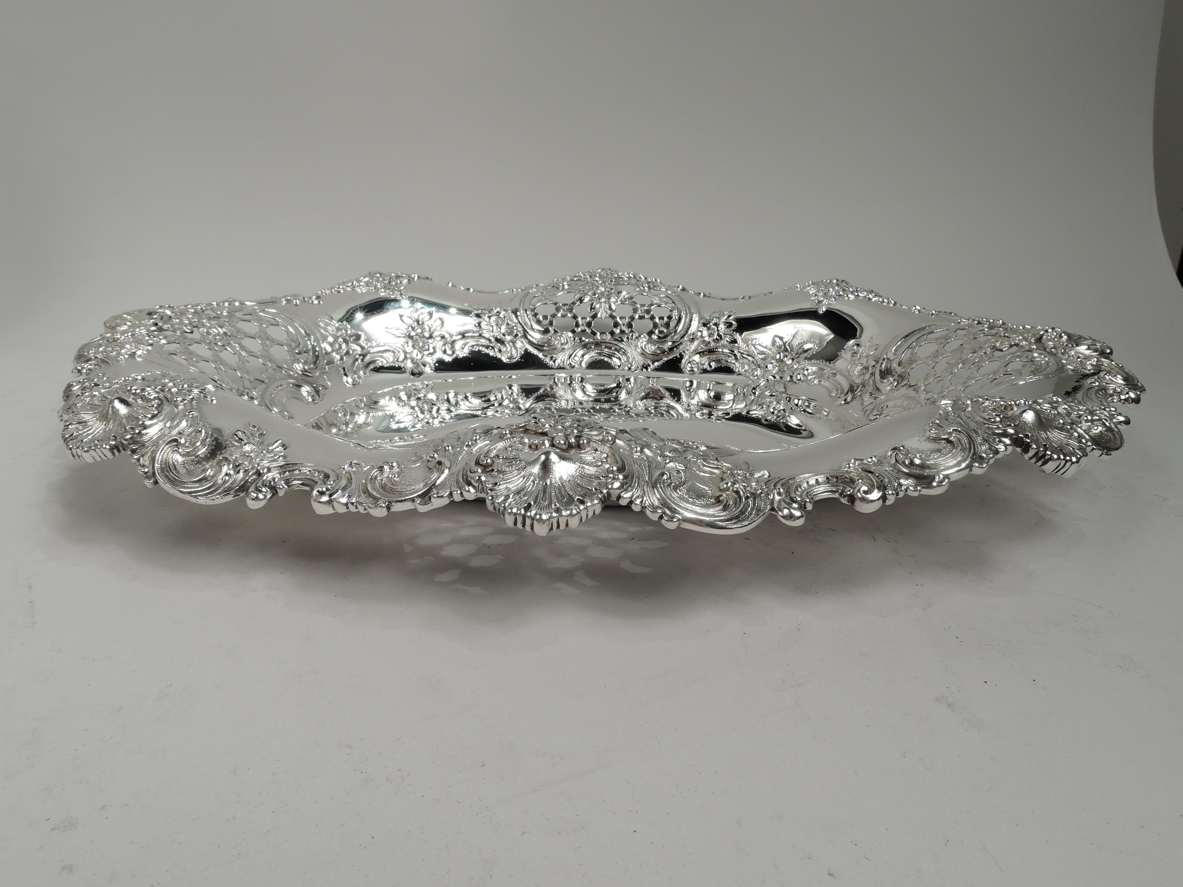 Victorian Classical sterling silver bowl. Made by Tiffany & Co. in New York. Solid oval well and wavy rim. Chased flowers and scrolls, and pierced and open floral lattice. Rim has applied scrolls, flowers, and scallop shells. Fully marked including