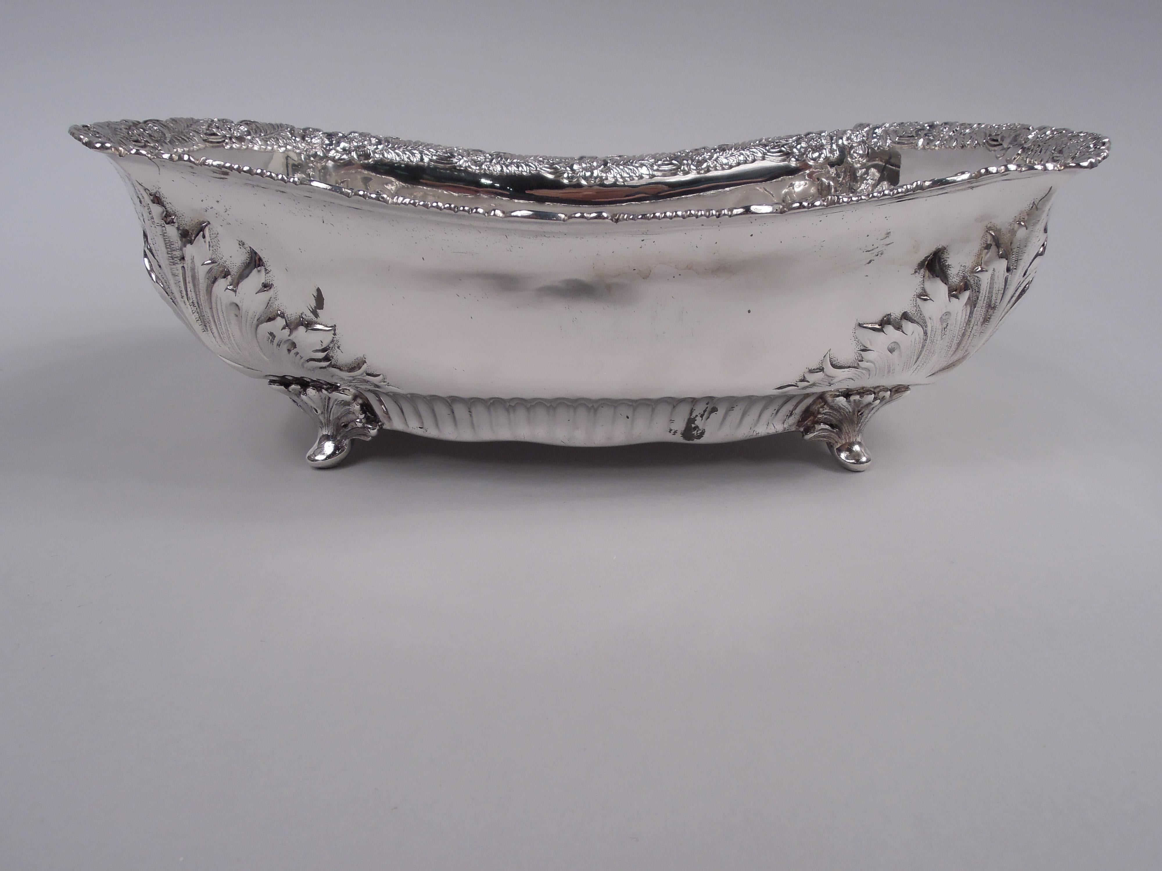 Victorian Classical sterling silver roll tray. Made by Tiffany & Co. in New York. Rectangular with curved and half-fluted sides. Cast leaf and flower rim; on corners chased acanthus leaves and leaf-mounted supports. Fully marked including maker’s