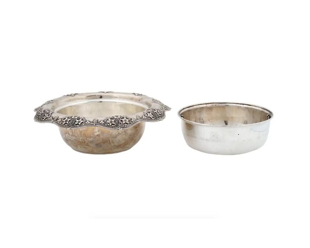 A fine quality antique Tiffany and Co round sterling silver bowl featuring an everted rim and a scalloped edge with pierced floral motif. With a matched silver insert bowl with two handle rings on the sides. 

The outer bowl is marked underneath: