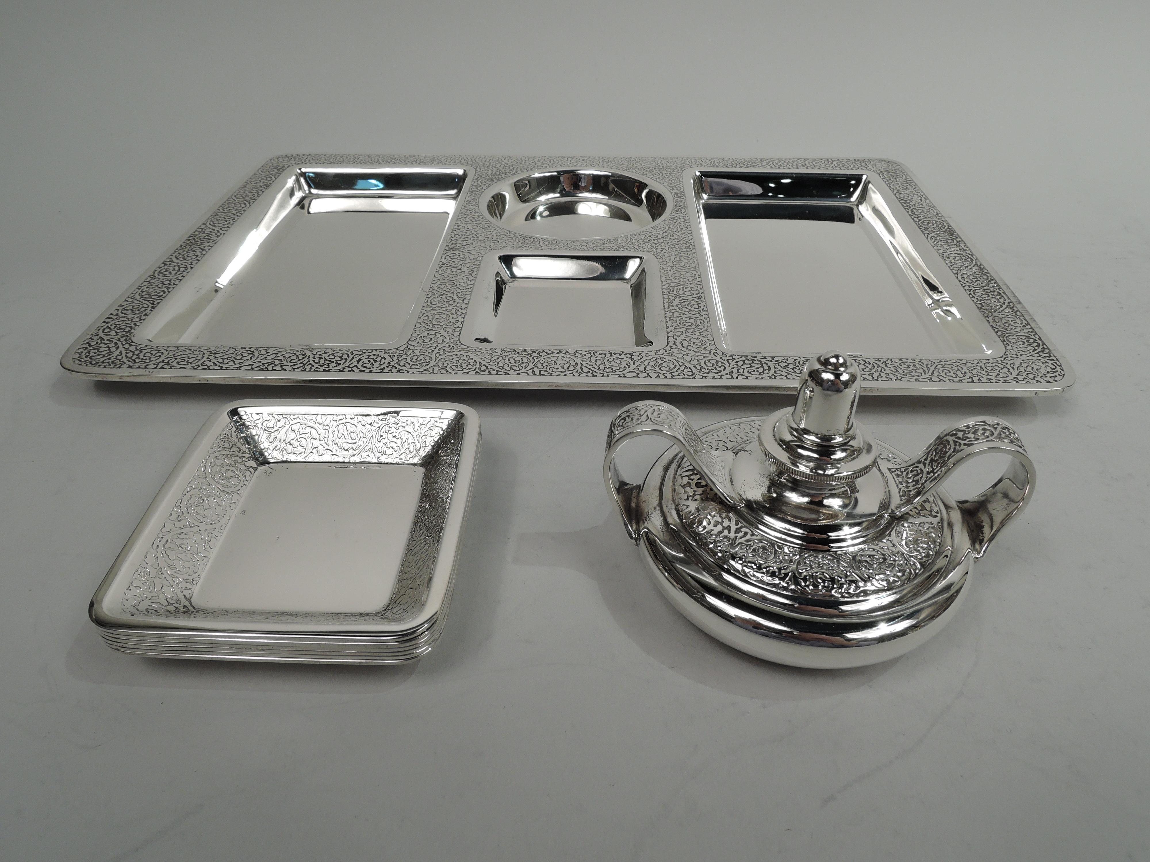 Art Deco sterling silver cigar set. Made by Tiffany & Co. in New York, circa 1920. This set comprises, tray, lighter, and 6 ashtrays. Tray rectangular with rounded corners and flat rim. Two central wells of which one rectangular for ashtrays and one