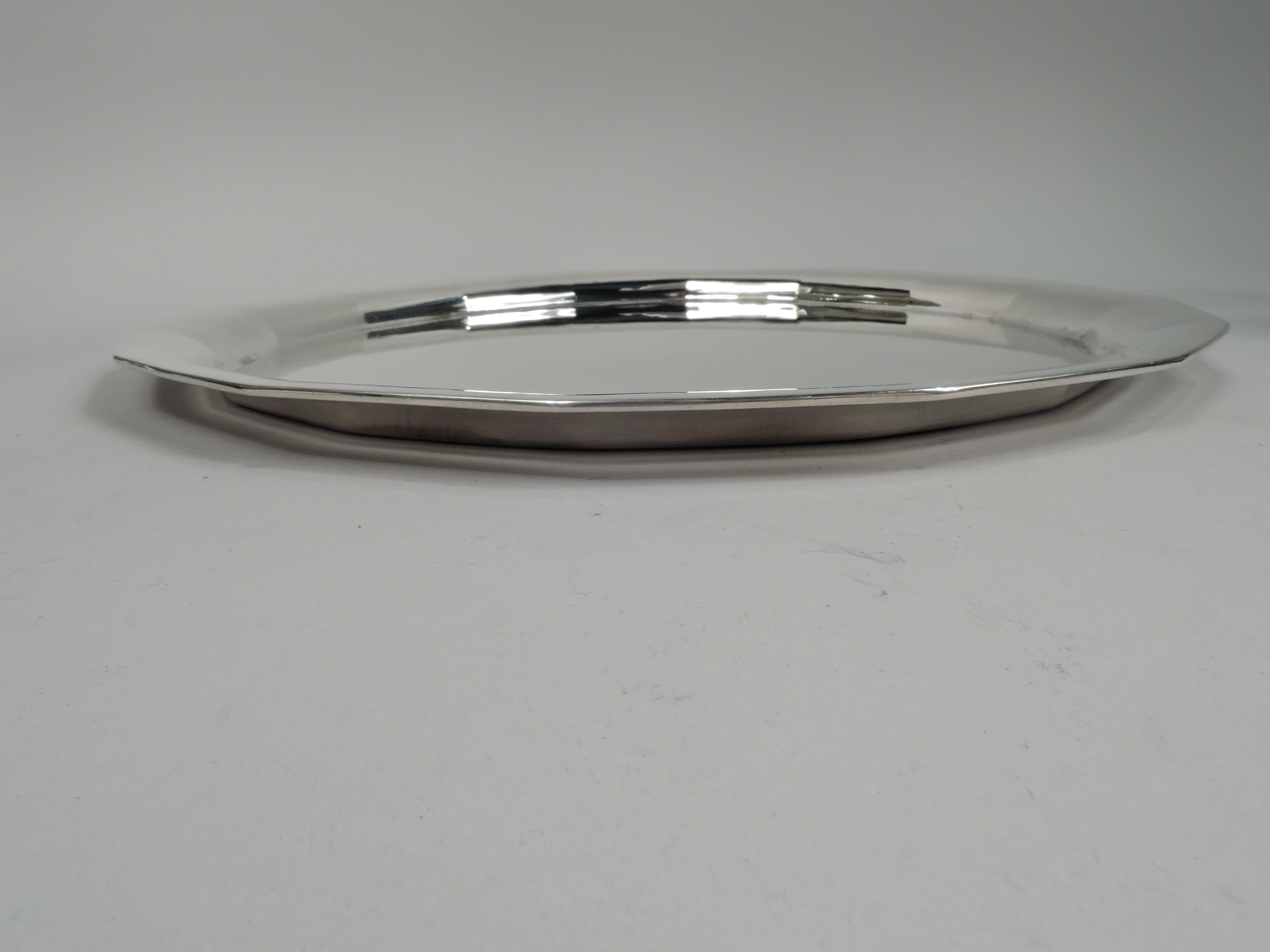Art Deco sterling silver tray. Made by Tiffany & Co. in New York, ca 1911. Round with soft faceting. A nice piece in the emerging geometric style. Fully marked including maker’s stamp, pattern no. 18072 (first produced in 1911), and director’s