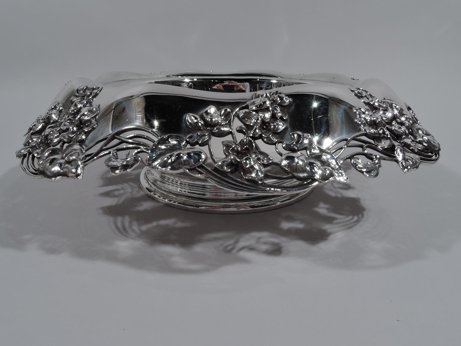 Art Nouveau sterling silver centerpiece bowl. Made by Tiffany & Co. in New York. Deep with curved bottom and stepped foot. Wide turned-down shoulder with applied flowers and wavy wire tendril rim. Fully marked including pattern no. 15484A (first