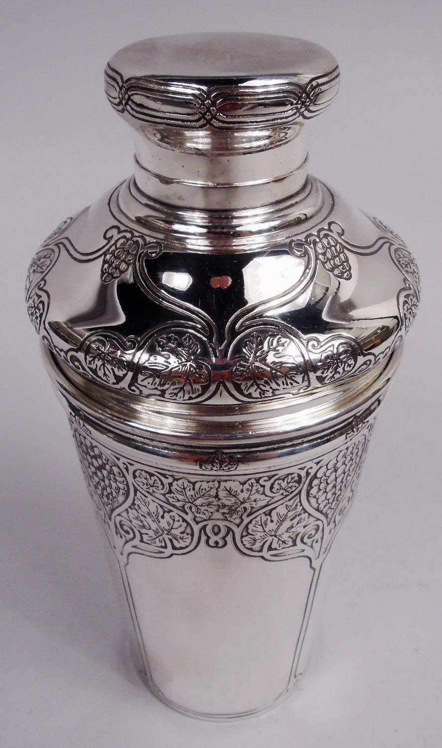 Art Nouveau sterling silver cocktail shaker. Made by Tiffany & Co. in New York, ca 1915. Tapering bowl. Cover bellied; central pierced well spout with plug. Acid-etched stylized ornament comprising leaves and berries in curvilinear frames in