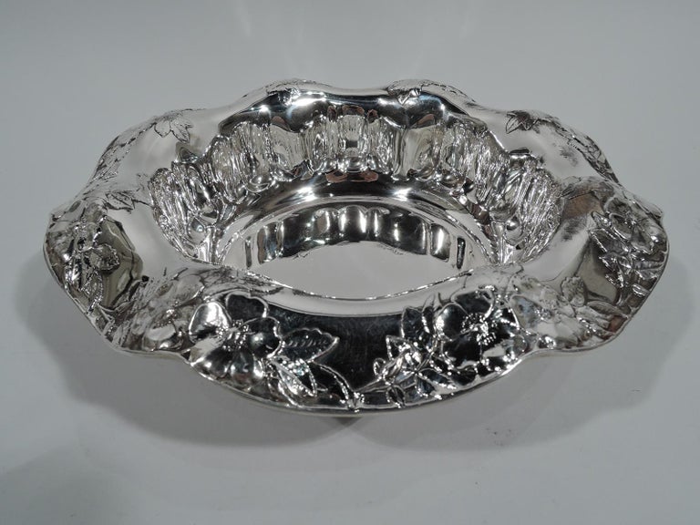 Art Nouveau sterling silver flower bowl. Made by Tiffany & Co. in New York, circa 1910. Sides have abstract egg-and-dart border. Wavy turned-down rim with applied flower-and-leaf pattern. Fresh and pretty with nice heft. Fully marked including
