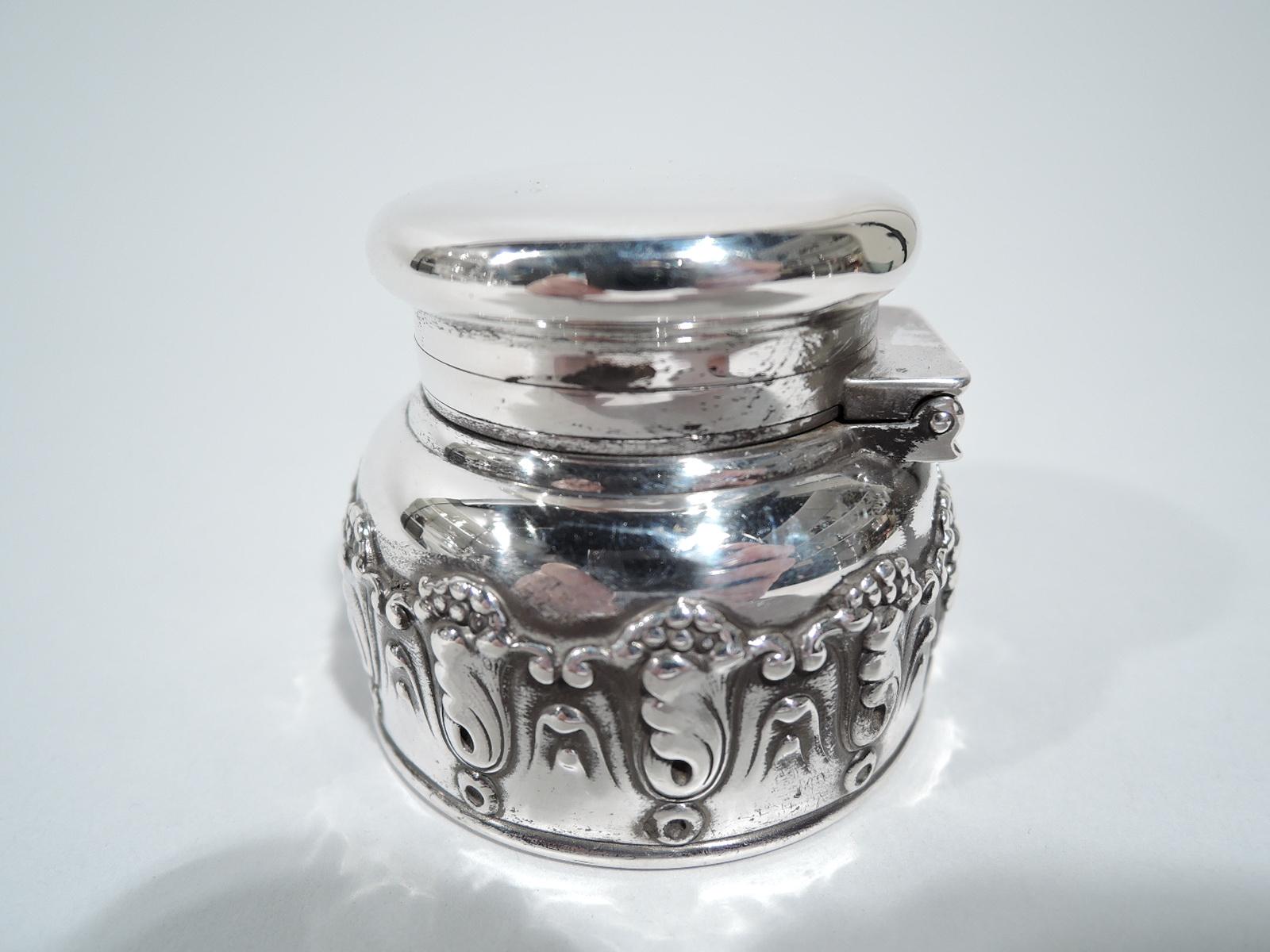 Art Nouveau sterling silver traveling inkwell. Made by Tiffany & Co. in New York. Round bowl with applied scrolling leaf and berry border, and curved shoulder. Cover flat, hinged, and overhanging. Bowl interior glass lined with poignant evidence of