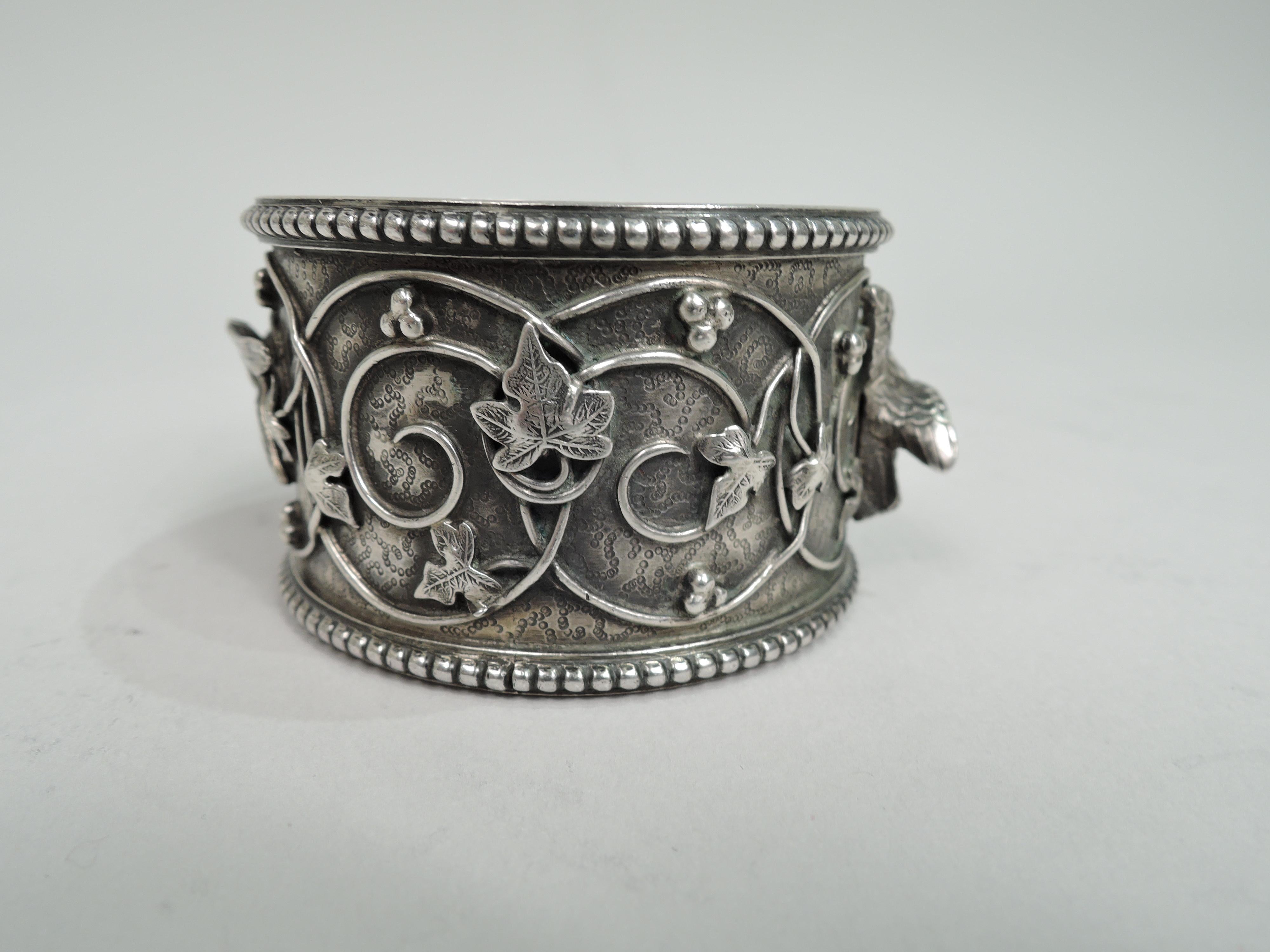 Bird’s Nest sterling silver napkin ring. Made by Tiffany & Co. in New York, ca 1890. Leafing wire rinceaux and 2 cast birds on patterned ground. Beaded rims. Engraved in interior: “1st Christmas 1891”. A fabulous piece in the historic pattern.