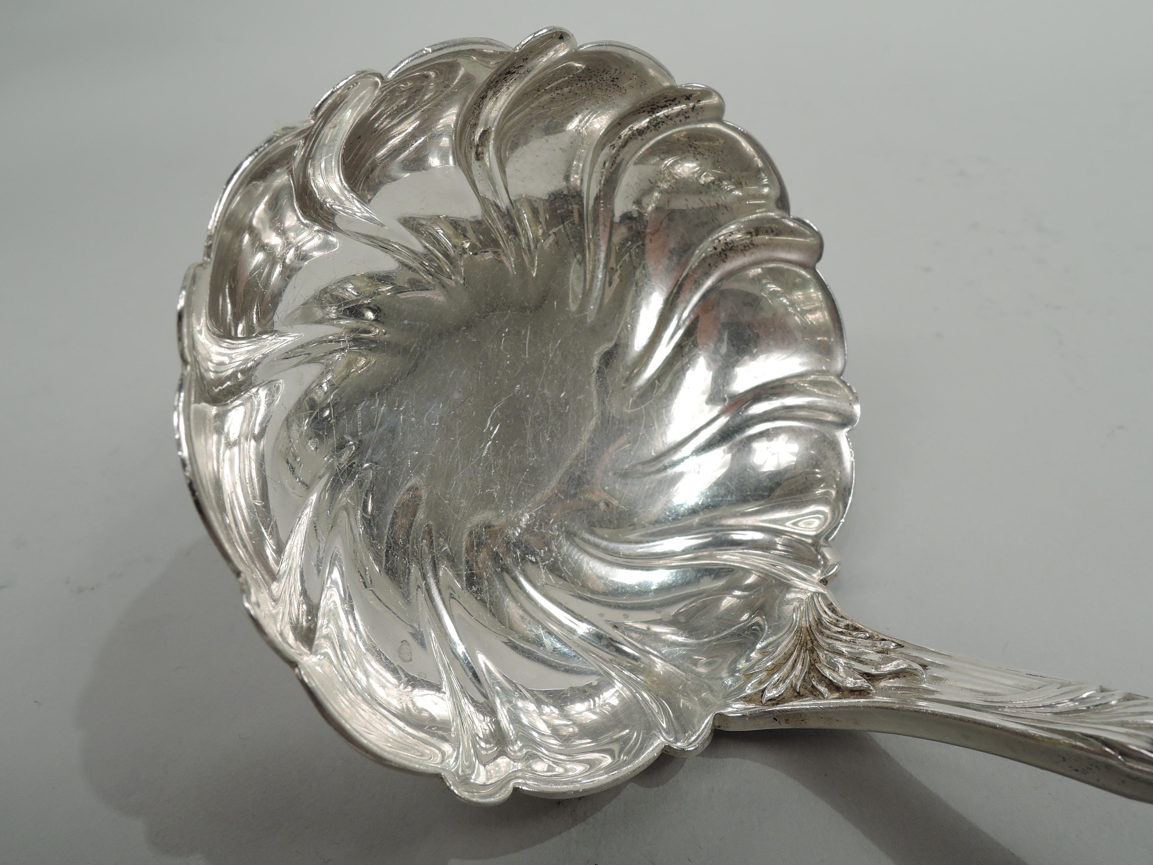 Chrysanthemum sterling silver oyster ladle. Made by Tiffany & Co. in New York, ca 1920. Round bowl with twisted fluting and curved and reeded stem with dense entwined and wraparound leaves embedded with flower heads; large flower head at terminal. A