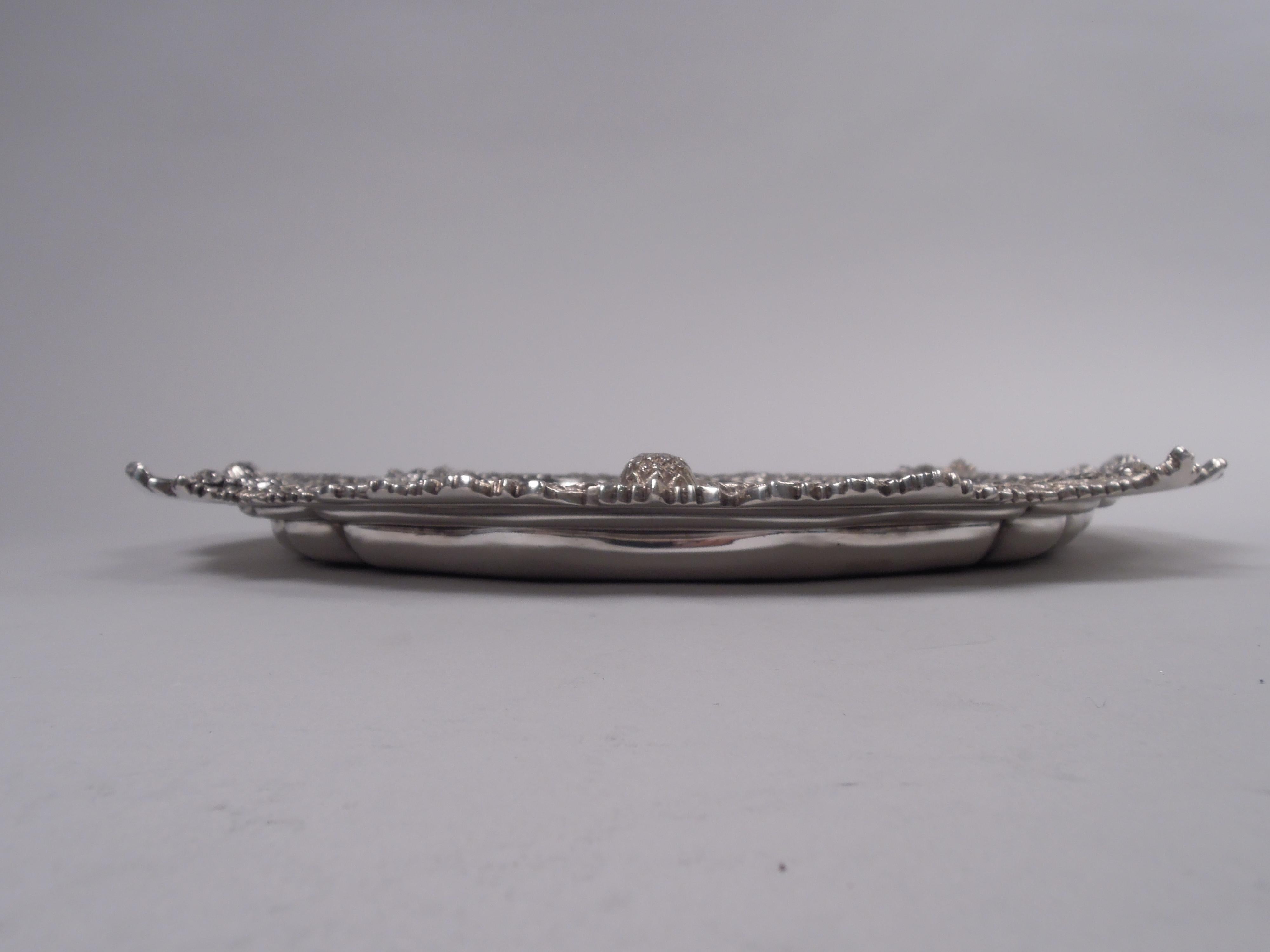 Bandeja crisantemo de plata de ley. Fabricado por Tiffany & Co. en Nueva York. Pozo redondo de serpentina grabado con escudo de armas. Borde fundido en forma de densas hojas superpuestas intercaladas con cabezas florales. Una hermosa pieza en el