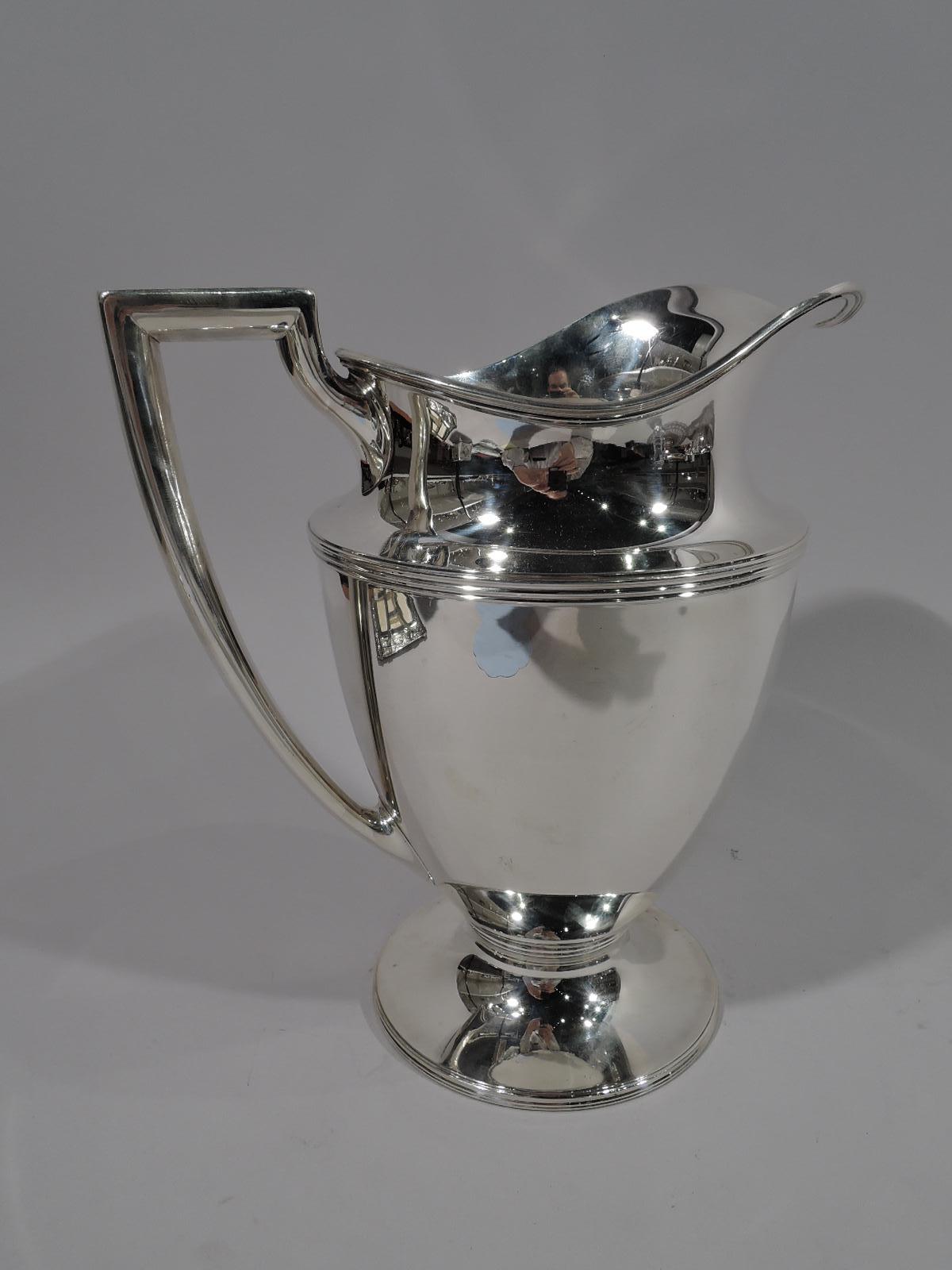 Classic sterling silver water pitcher. Made by Tiffany & Co. in New York, circa 1911. Helmet mouth, ovoid body, raised and stepped foot, and scrolled-bracket handle. Reeding. Fully marked including pattern no. 18181 (first produced in 1911) and