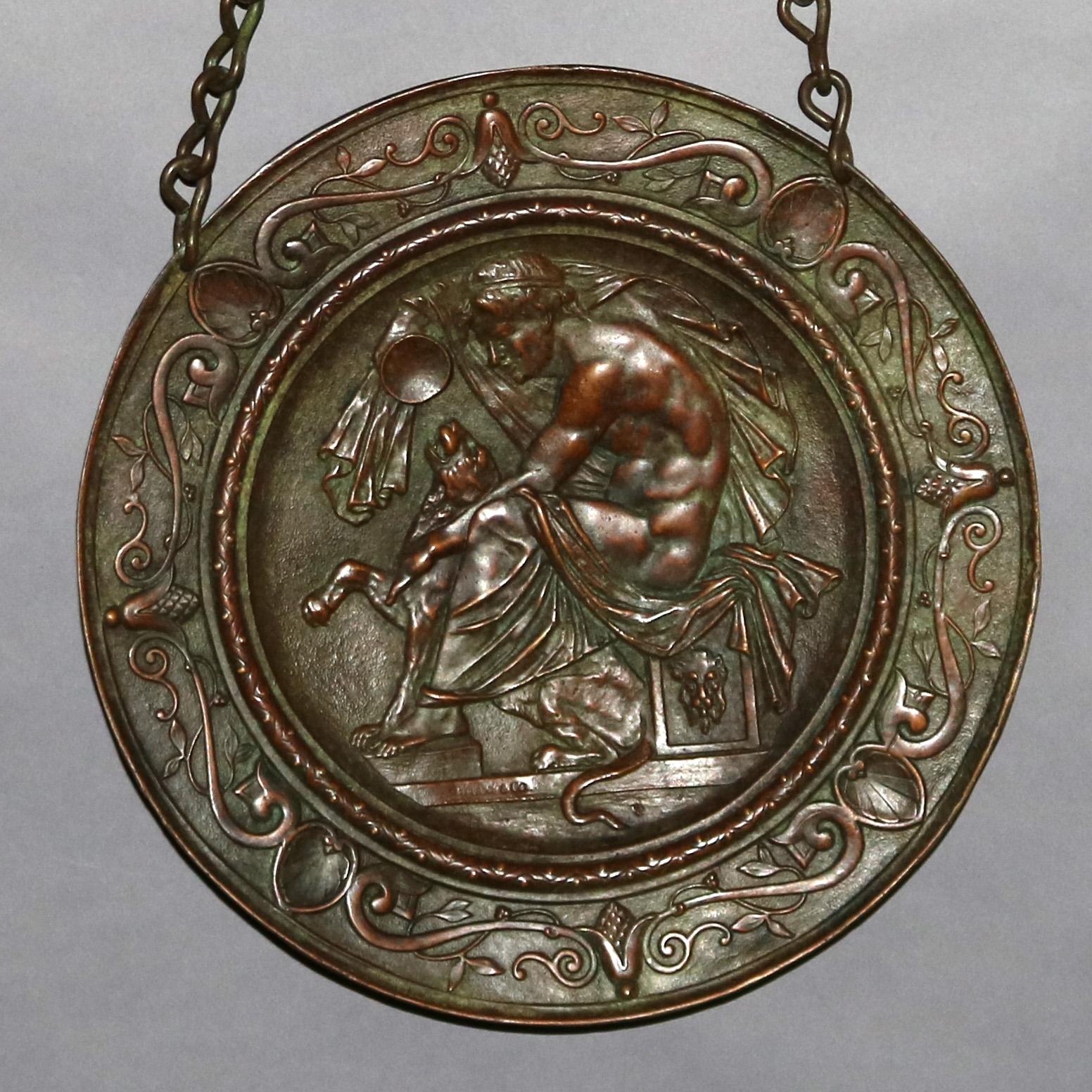 An antique hanging wall plaque by Tiffany & Co with Classical scene depicting partially nude man with lioness, surround with scroll, schell and foliate design, suspended by chain, stamped lower right as photographed, circa 1900.

Measures: .75